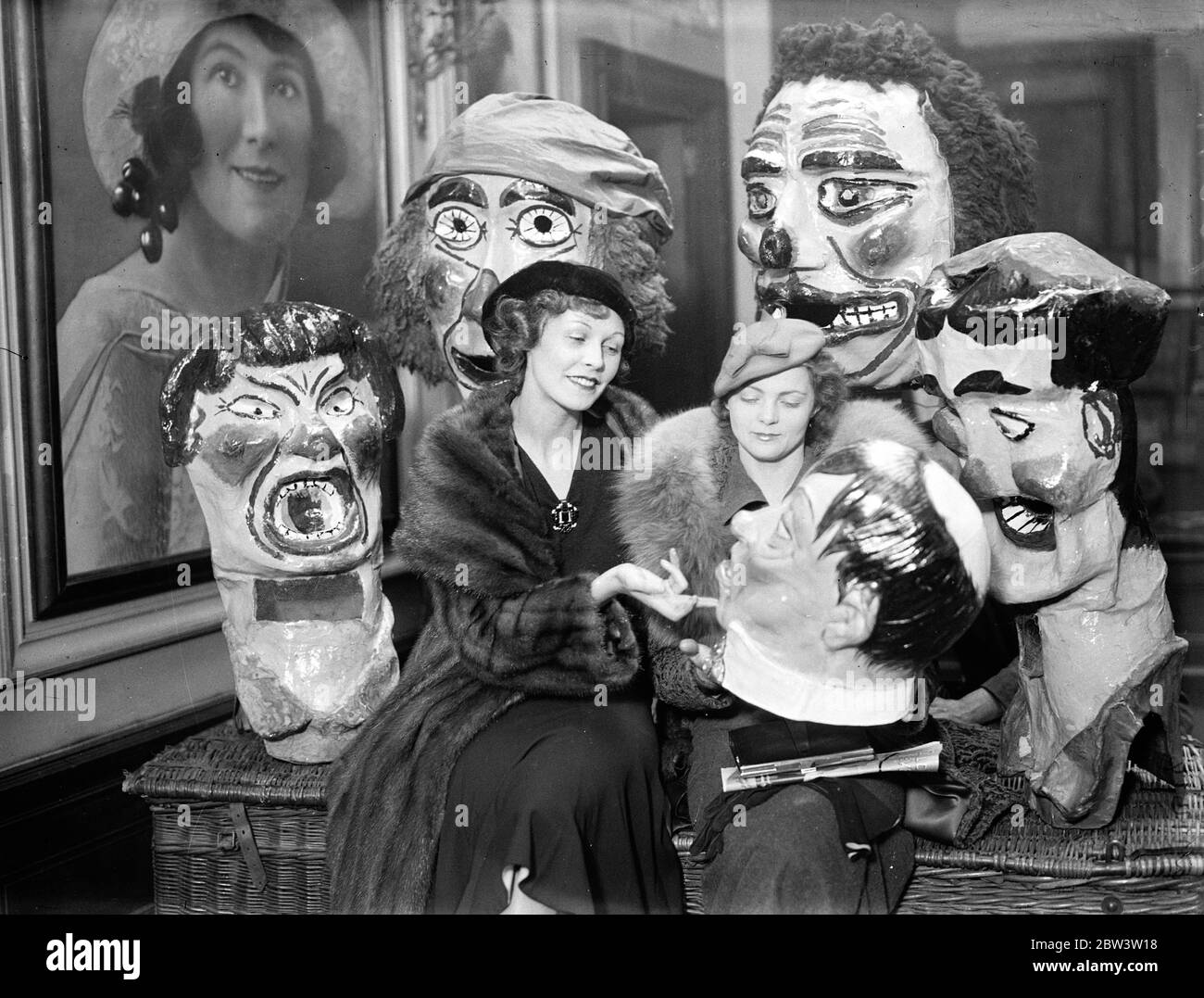 Victoria Hopper und Oriel Ross bei der Pantomime Probe in Shaftesbury Avenue, London. Victoria Hopper (rechts) und Oriel Ross diskutieren die Vorzüge einer Maske. Dezember 1935 Stockfoto