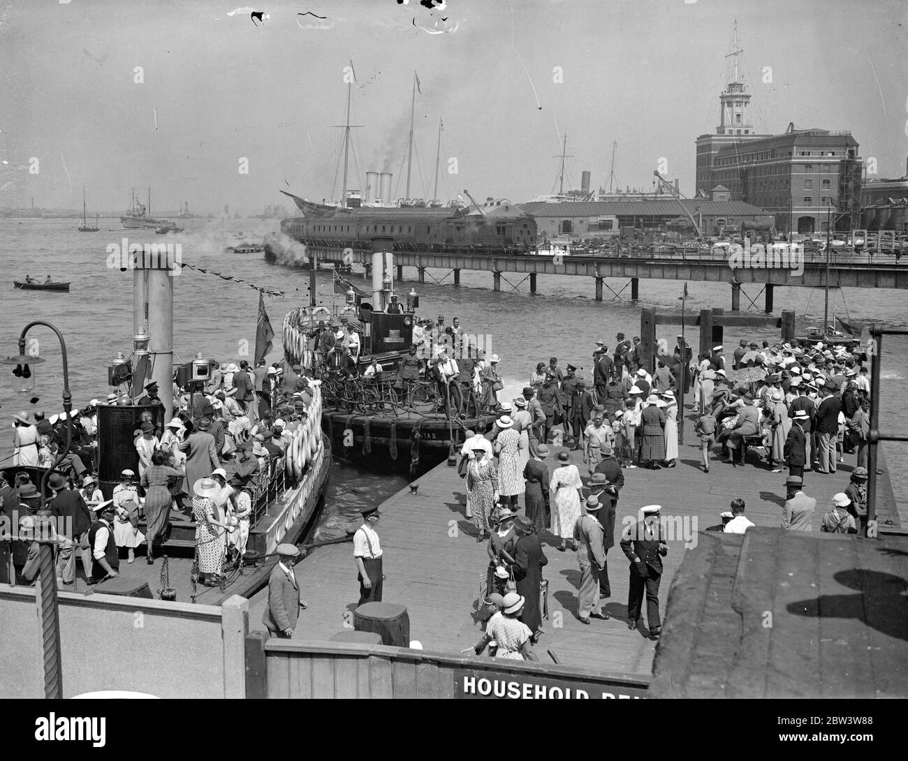 Riesige Menschenmassen in Portsmouth für eine Bewertung. Tolle Menschenmassen warten auf der Portsmouth bis Gosport Fähranlegestelle, um Boote zu ihren Positionen für die King 's Marine Review zu bekommen. Die Royal Yacht Victoria und Albert ist im Hintergrund. 16 Juli 1935 Stockfoto