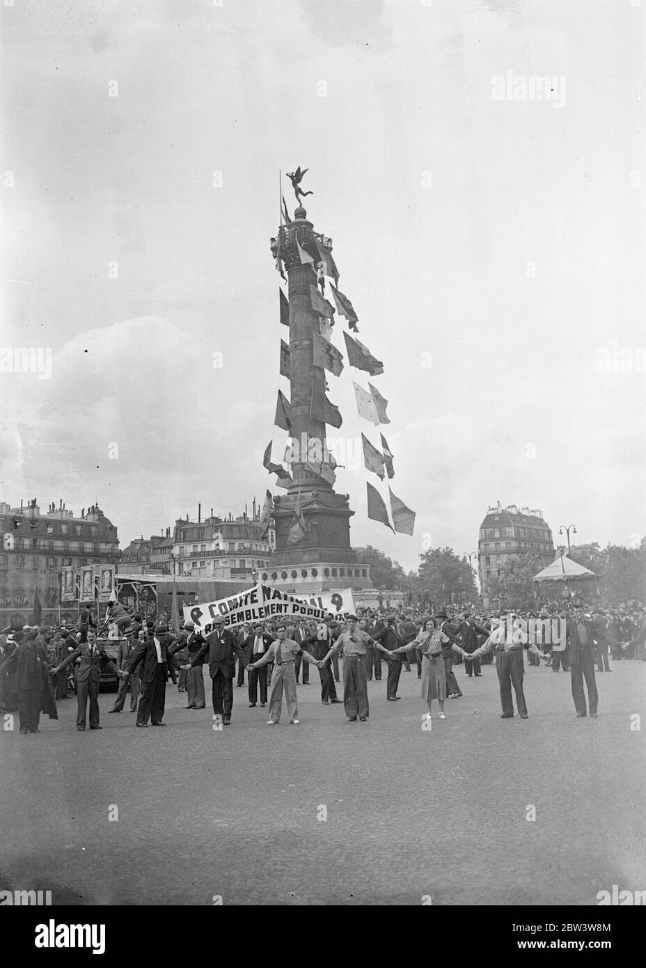 Volksfront Mitglieder Parade In Paris Während Jahrestag Feiern Des Falls Der Bastille . Tausende von Mitgliedern der Volksfront, angeführt von ihren Führern, marschierten durch die fröhlich geschmückten Straßen von Paris in Monster Prozessionen während der Jubiläumsfeiern des Falls der Bastille in der Französischen Revolution. Große Kräfte der Polizei und mobile Wachen patrouillierten auf den Straßen, um Unruhen zu verhindern. Foto zeigt : Volksfront Feiern auf dem Place de la Bastille . Juli 1936, 14 Stockfoto