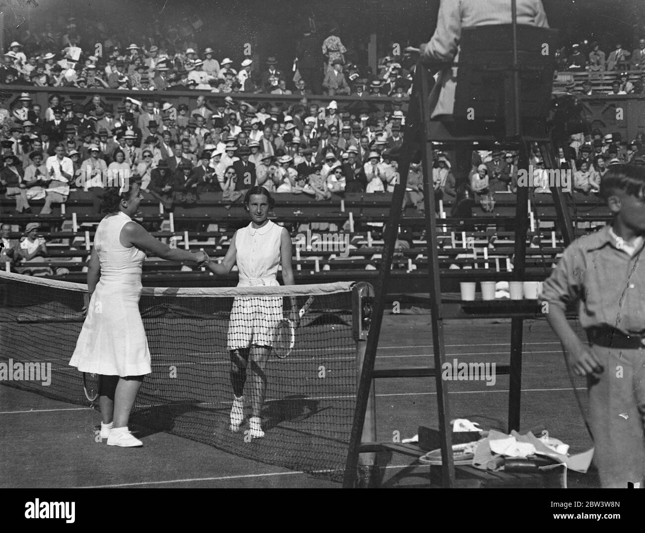 Dorothy Round besiegt Betty Nutall in den Frauen-Singles bei WimbledonTennis Championships . Miss Dorothy Round hatte ihren ersten Erfolg in ihrem Versuch, ihren Wimbledon-Titel wieder zu erlangen, als sie Miss Betty Nuthall 9 - 7, 6 - 3 in der ersten Runde der Frauen-Singles in Wimbledon besiegte. Foto zeigt: Dorothy Runde wird von Betty Nuthalle nach dem Spiel auf dem Center Court gratuliert. 23 Juni 1936 Stockfoto