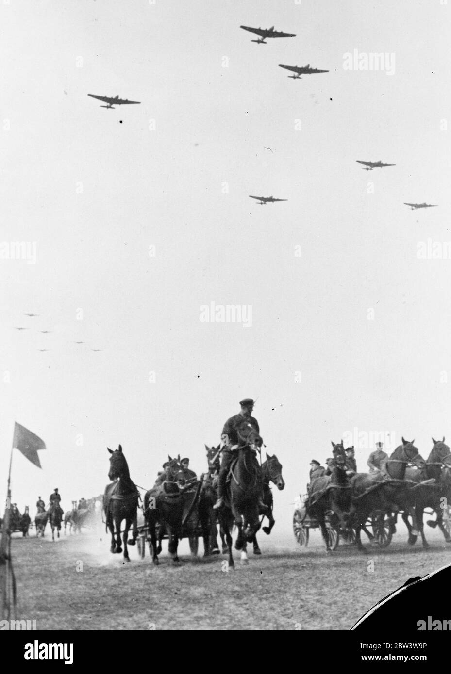 Die Rote Armee führt ihre größten Manöver durch. Sowjetische bewaffnete Macht auf Parade . Militärflugzeuge fliegen über Maschinengewehrwagen von Kavallerie gezogen. 1935 Stockfoto