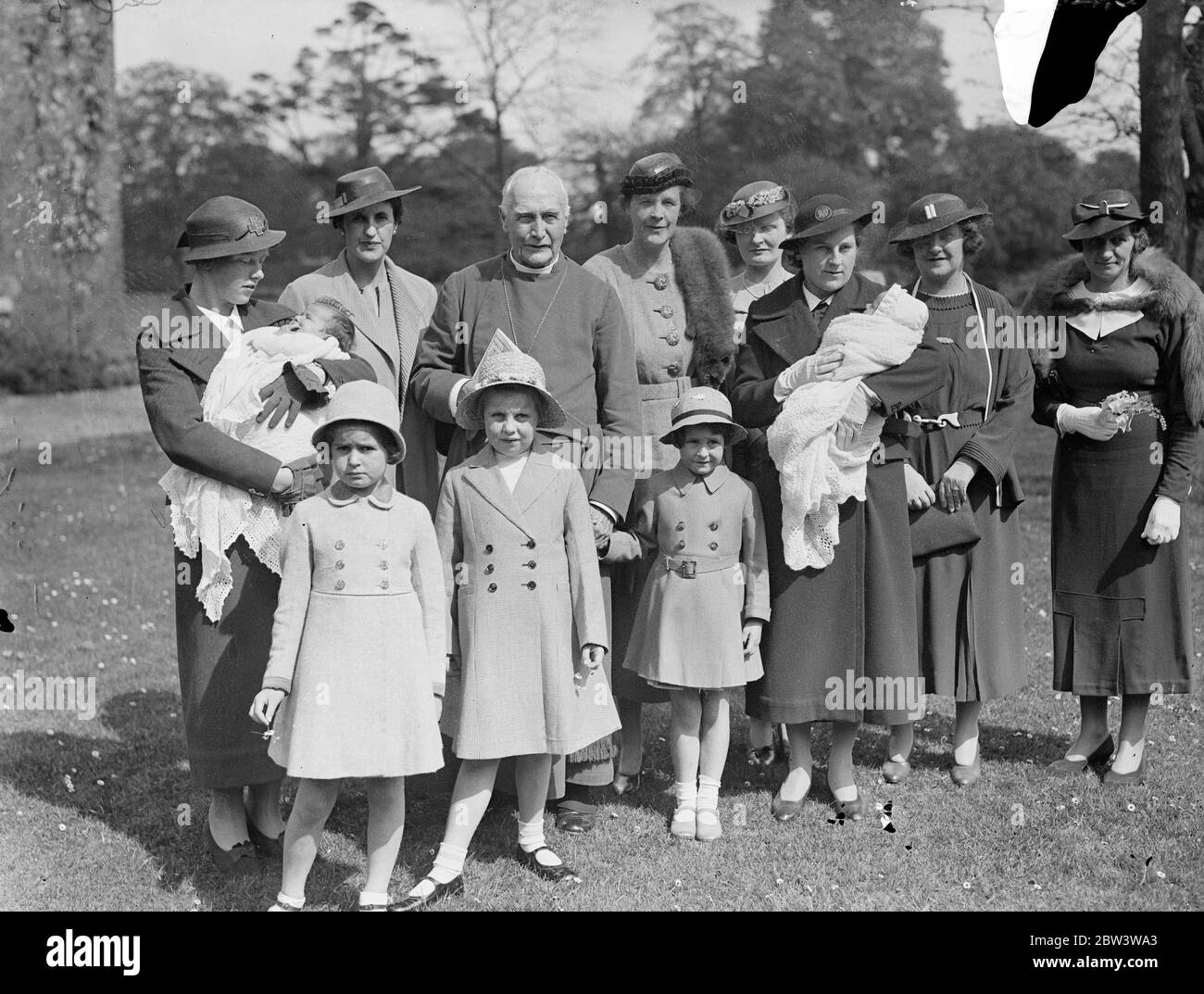 Frauen Tennisspielerinnen Töchter haben Doppeltaufe am Fulham Place. Die Töchter von zwei bekannten Wimbledon Tennisspielern wurden zusammen im Fulham Palace vom Bischof von London getauft. Sie waren Patricia, Tochter von Frau L R C Michell, und Rosamund, Tochter von Frau Michell ' s Schwester, Frau W. R. Findlay. Foto zeigt, der Bischof von London, Dr. Winnington Ingram, mit der Taufe Partei in Fulham Palace. Frau LRC Michell ist neben dem Bischof (links) und Frau W B Findlay ist neben dem Bischof auf der rechten Seite. 14 Mai 1936 Stockfoto