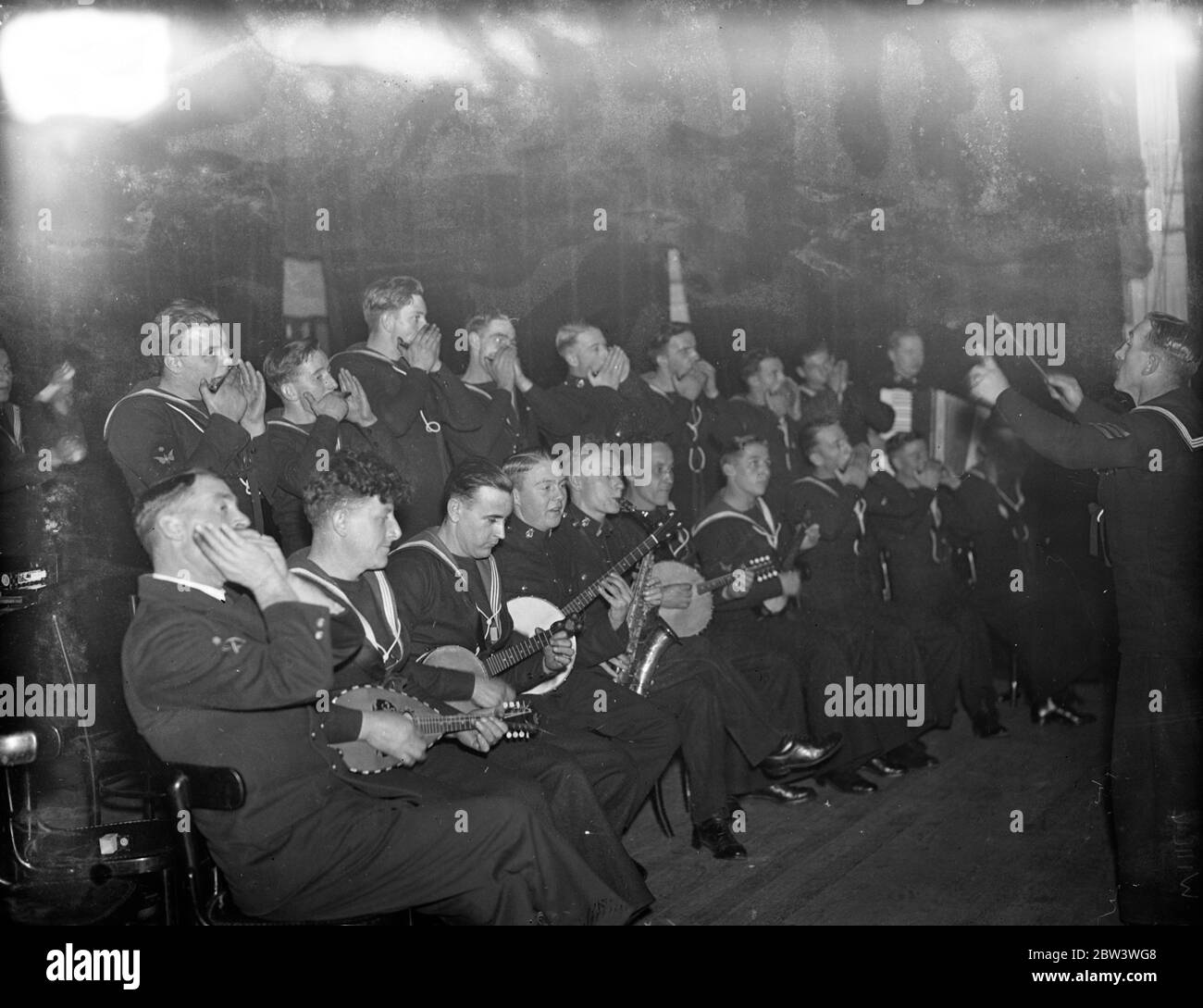 H M S Rodney ' s Mundharmonika-Band spielen in London, um Wohltätigkeit zu unterstützen. Die Offiziere und Ratings von HS Rodney haben eine Mundharmonika-Band und eine Konzertparty gegründet, um Wohltätigkeitsorganisationen zu helfen. Sie demonstrierten ihr Vorzeichen bei einer Aufführung zur Unterstützung der Selbsthilfe-Mission der Kinder im Rathaus von Battersea. 27. November 1935 Stockfoto