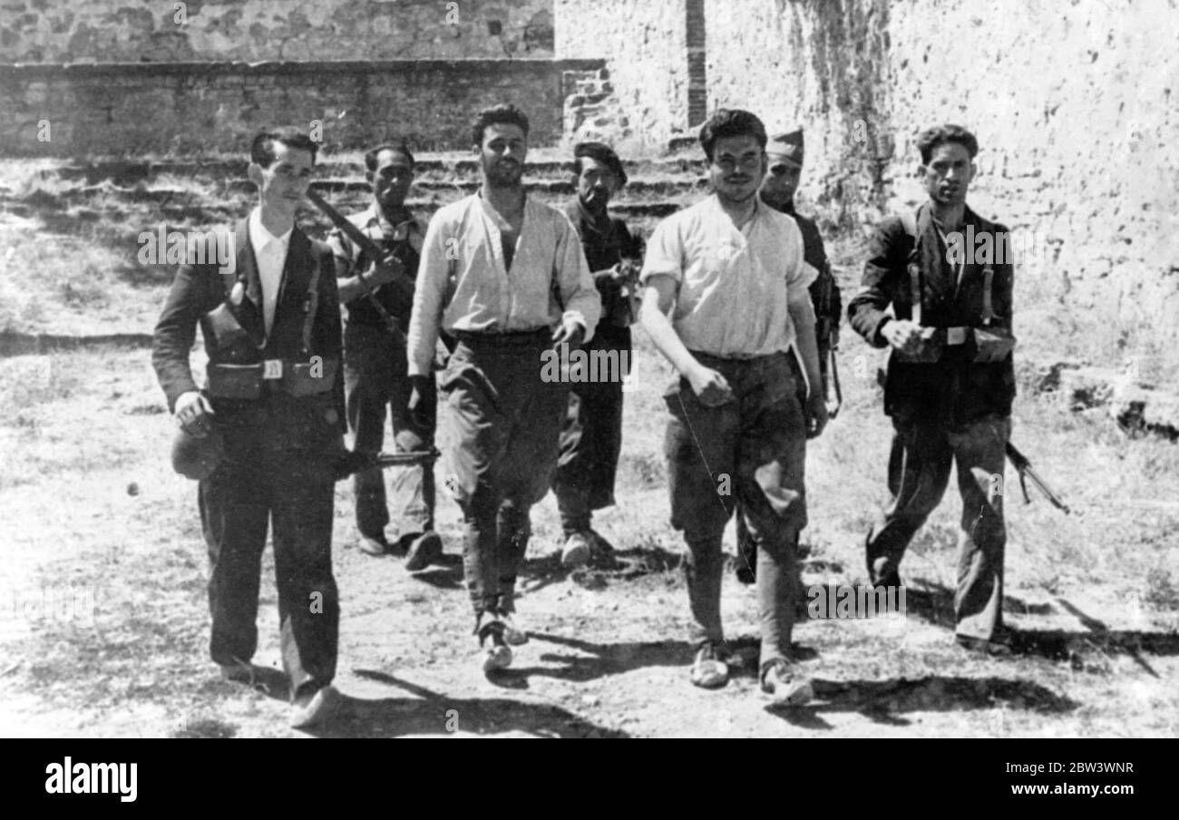 Spanische Rebellen Deserteure von loyalen Milizionären bewacht . Fröhlich lächelnd durch einen Bartstoppel marschieren zwei Deserteure der spanischen Rebellenkräfte, bewacht von Männern der Regierungsmiliz, die sich an dem Vormarsch der Loyalisten auf Saragossa aus dem Süden beteiligt haben. Die Deserteure, die gebeten, sich den Regierungskräften anzuschließen, tragen noch ihre Armee Hosen, und scheinen unbesorgt über die Vortriebsklinken der Männer hinter. Bis 18. August 1936 Stockfoto