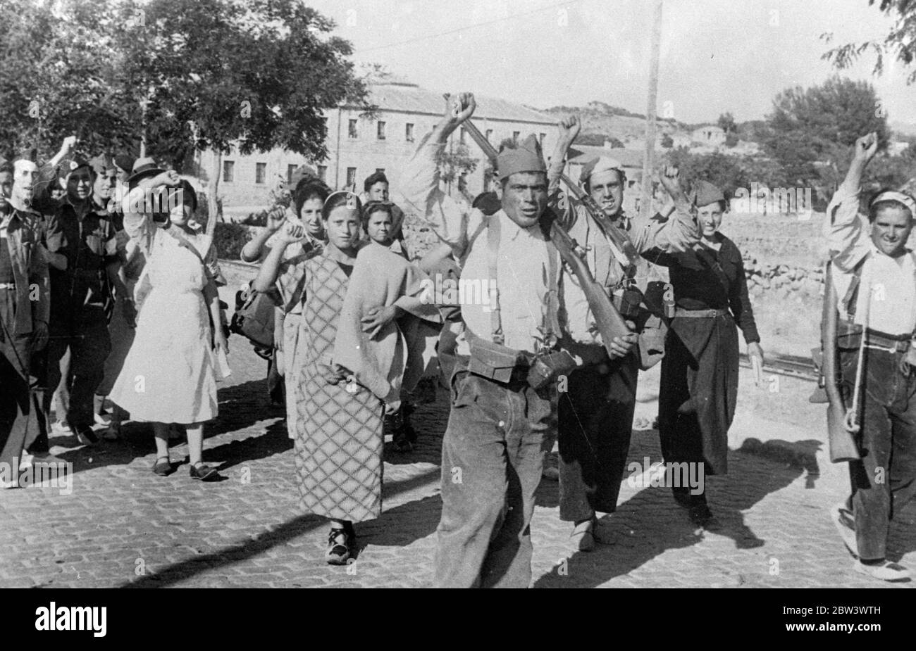 Solidarisch Marschieren Frauen Trotzig In Die Schlacht Im Guadarrama . Einige von ihnen in einfachen Haushaltsoveralls gekleidet, mehr Frauen sind ihre Manfolk in der Bekämpfung der Rebellen in der Guadarrama Bezirk von Spanien, wo eine unerbittliche Kriegsführung wird mit großer Härte für beide Seiten durchgeführt. Foto zeigt: Frauen, die die kommunistische geballte Faust grüßen, als sie marschieren, um gegen die Kräfte von General Emilio Mola zu kämpfen, Rebell comander in Alto de Leon. August 1936, 10 Stockfoto