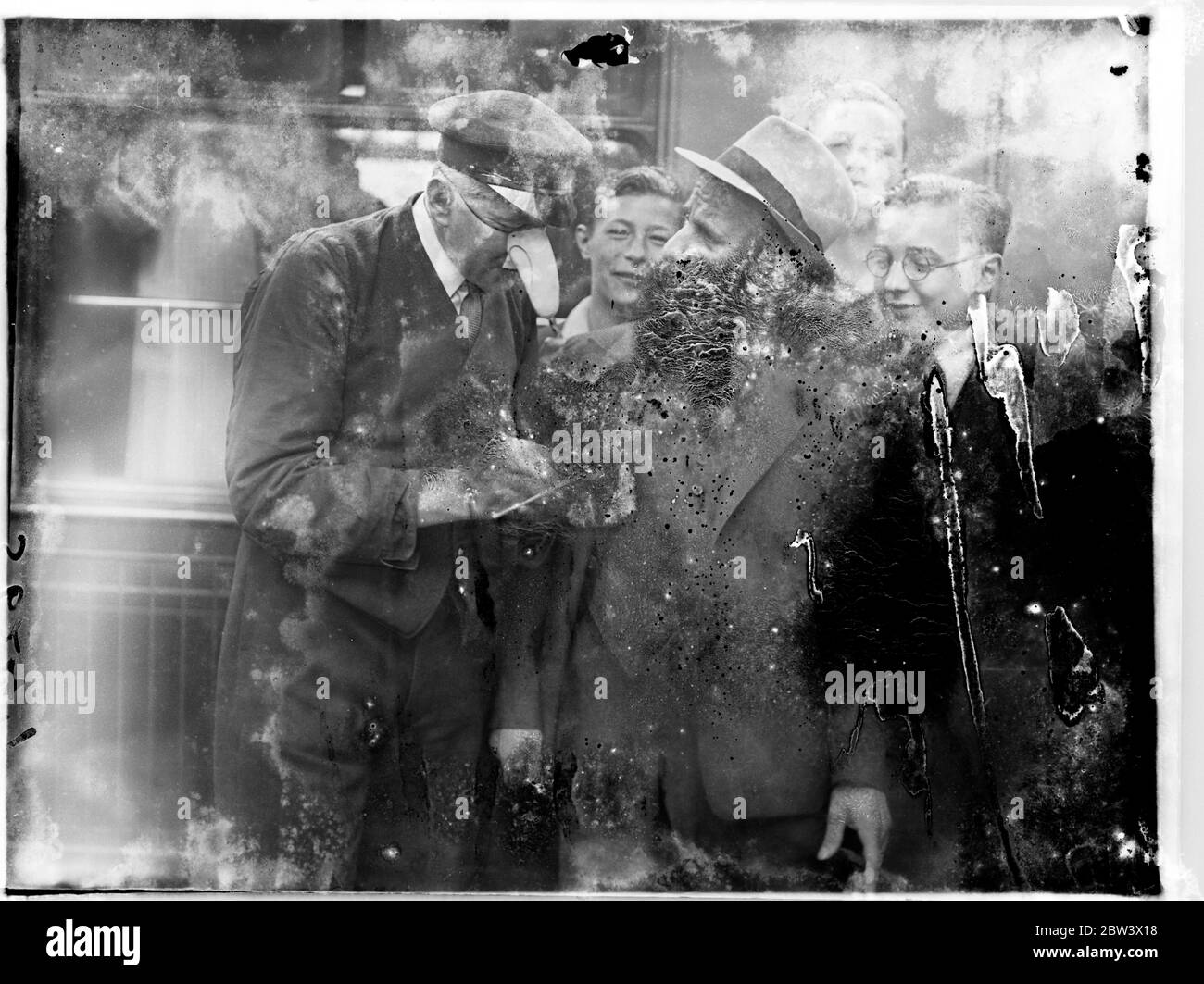 Jimmy Durante Sport Autogramme mit Porter ' s 'Rivale' für berühmte Nase! Jimmy ( Schdüse ) Durante fand seine berühmte Nase von Porters rivalisiert, als er Victoria Station für die Kontinentals nach Abschluss seines britischen Films "Land ohne Musik" verlassen. Der Portier hatte sich extra für diesen Anlass die Nase aufgesetzt. Er hatte die Unterscheidung der Austausch Autogramme mit Durante. Foto zeigt, der Portier mit der übergroßen Nase, der sein Autogramm für Jimmy Durante in Victoria unterschreibt. Bis 13. August 1936 Stockfoto