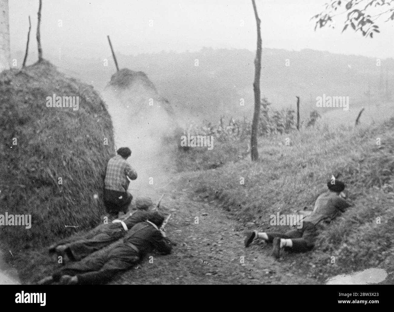 Heuhaufen bietet Deckung im Kampf bei Saragossa. Die spanischen Regierungskräfte geben den Rebellen viel Mühe in der Saragossa Bezirk , Gebiet, das von den Rebellen gehalten wird . Die Loyalisten benutzen Guerillataktiken offenbar mit beträchtlichem Erfolg. Foto zeigt : Regierung Milizionäre feuern aus einem Heuhaufen in der Nähe von Saragossa . 26. August 1936 Original-Bildunterschrift von Negativ Stockfoto
