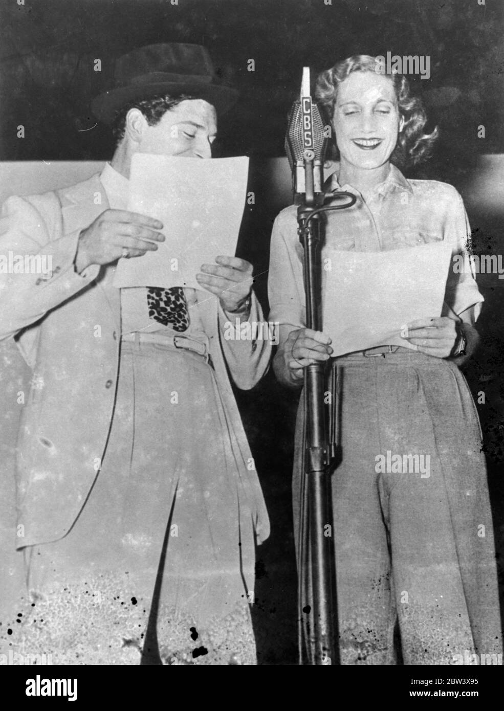Mrs Markham sehen Sie die lustige Seite ! . Frau Beryl Markham , glücklich trotz klebenden Gips , lächelt am Mikrofon, wie sie in New York bei der Ankunft aus Nova Scotia senden , als sie nach dem Flug den Atlantik abgestürzt . Links ist Milton Beryl , amerikanischer Bühnen- und Radiokomiker. Bushs 14. September 1936 Stockfoto