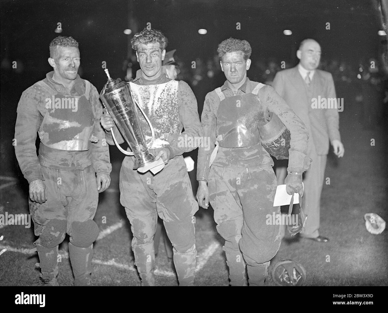 Lionel van Praag, der australische internationale und Wembley Kapitän wurde der erste Welt ' s Speedway Champion im Wembley Stadium, London. Am Ende des Jahres 20 führt Van Praag und Eric Langton von Belle Vue , Manchester , mit 26 Punkten gebunden . Van Praag besiegte Langton im Dezider. Bluey Wilkinson von West Ham war Dritter. Foto zeigt: Lionel van Praag (Mitte) mit Eric Langton, Läufer - oben (links) und Bluey Wilkinson, Dritter, nach dem Wettkampf. 11. September 1936 Stockfoto