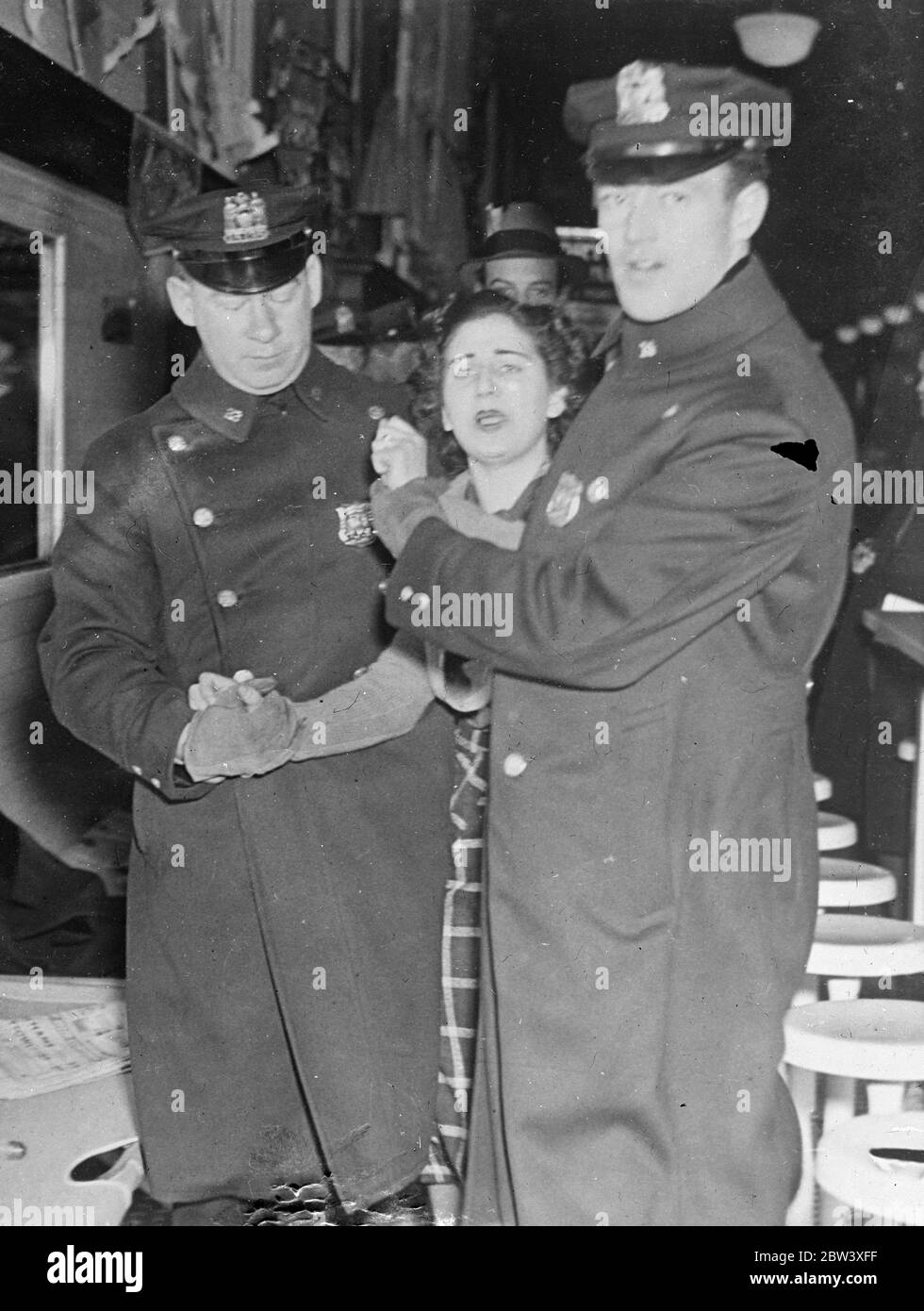Foto zeigt: Molly Kirsch, eine Assistentin, protestierte mit vollem Protest, als sie von zwei Polizisten aus dem Woolworth-Geschäft in der West 14th Street, New York, begleitet wurde, als die Geschäftsführung die Polizei einrief, Streikende zu vertreiben, die versuchten, das Gelände zu besetzen. Streikende, die sich der Polizei widersetzten, wurden festgenommen. 24. März 1937 Stockfoto