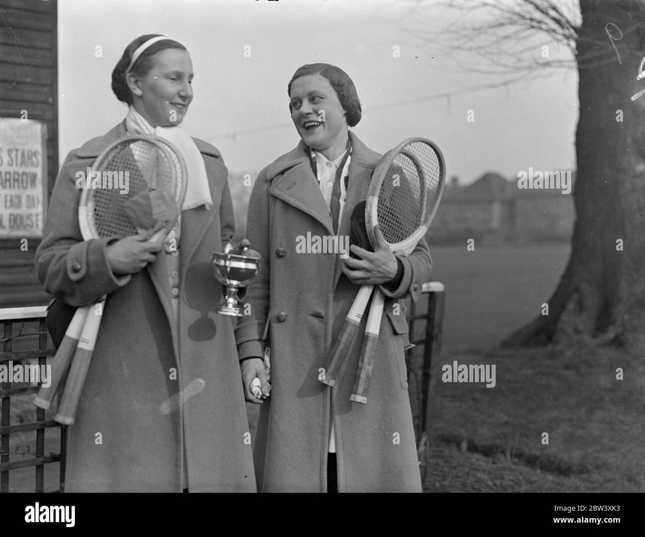 Miss Dorothy Round schlug Miss Mary Heeley im Finale der Frauen-Singles beim Herga Club Tennisturnier Harrow. Der Score war 4-6 6-3 6-3 Foto zeigt Miss Round (Holding Cup) mit Miss Heeley nach ihrem Spiel. März 1937 Stockfoto