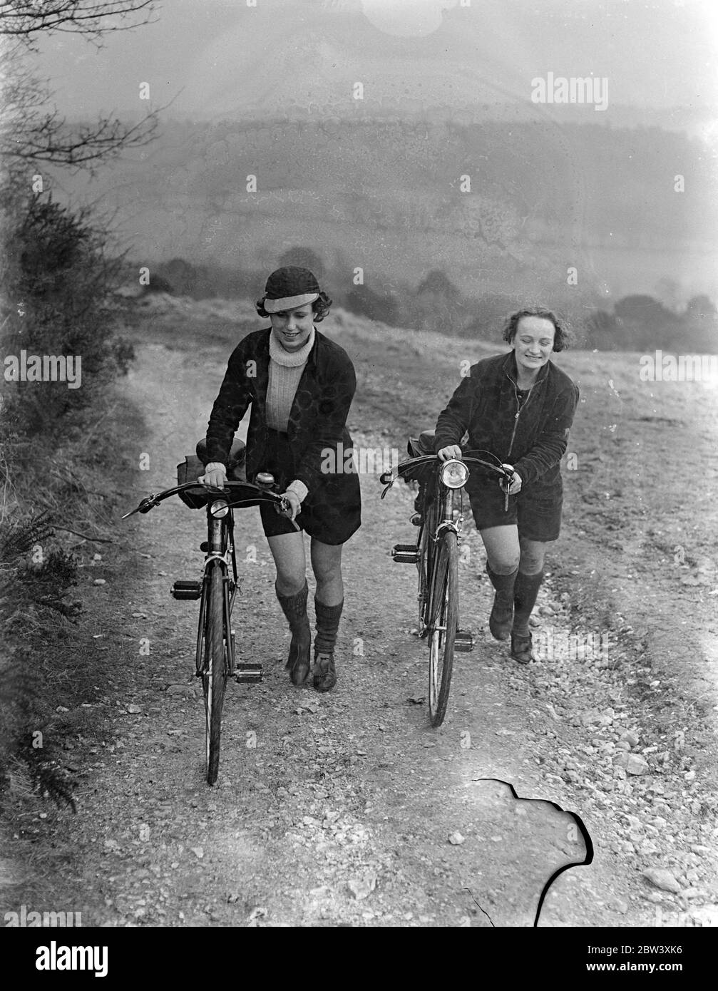 Foto zeigt: Radfahrerinnen, die ihren Urlaub mit dem Rad verbracht haben und die herrliche Aussicht auf Newlands Corner, dem berühmten Surrey Beauty Spot zwischen Dorking und Guildford, bewundern. 28 März 1937 Stockfoto