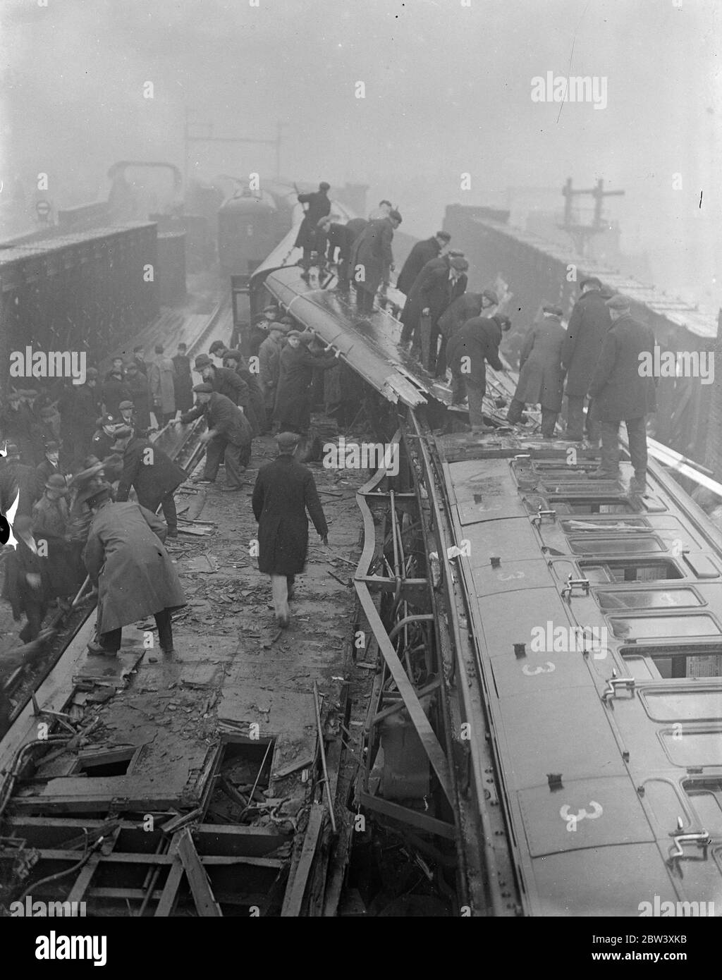 12 Menschen wurden getötet und fast 50 verletzt, als die elektrischen Züge an der Fourspan Bridge zwischen Queen's Road und Battersea Park Station direkt kollidierten. Die Busse wurden teleskopiert und umgedreht. Foto zeigt: Ein allgemeiner Blick auf die Szene des Einschlaffs. Bilder, die wenige Minuten nach dem Unfall aufgenommen wurden. April 1937 Stockfoto