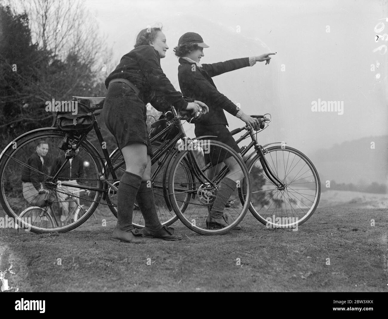 Foto zeigt: Radfahrerinnen, die ihren Urlaub am Rad verbringen und die herrliche Aussicht auf Newlands Corner bewundern, dem berühmten Surrey Beauty Spot zwischen Dorking und Guildford. 28 März 1937 Stockfoto