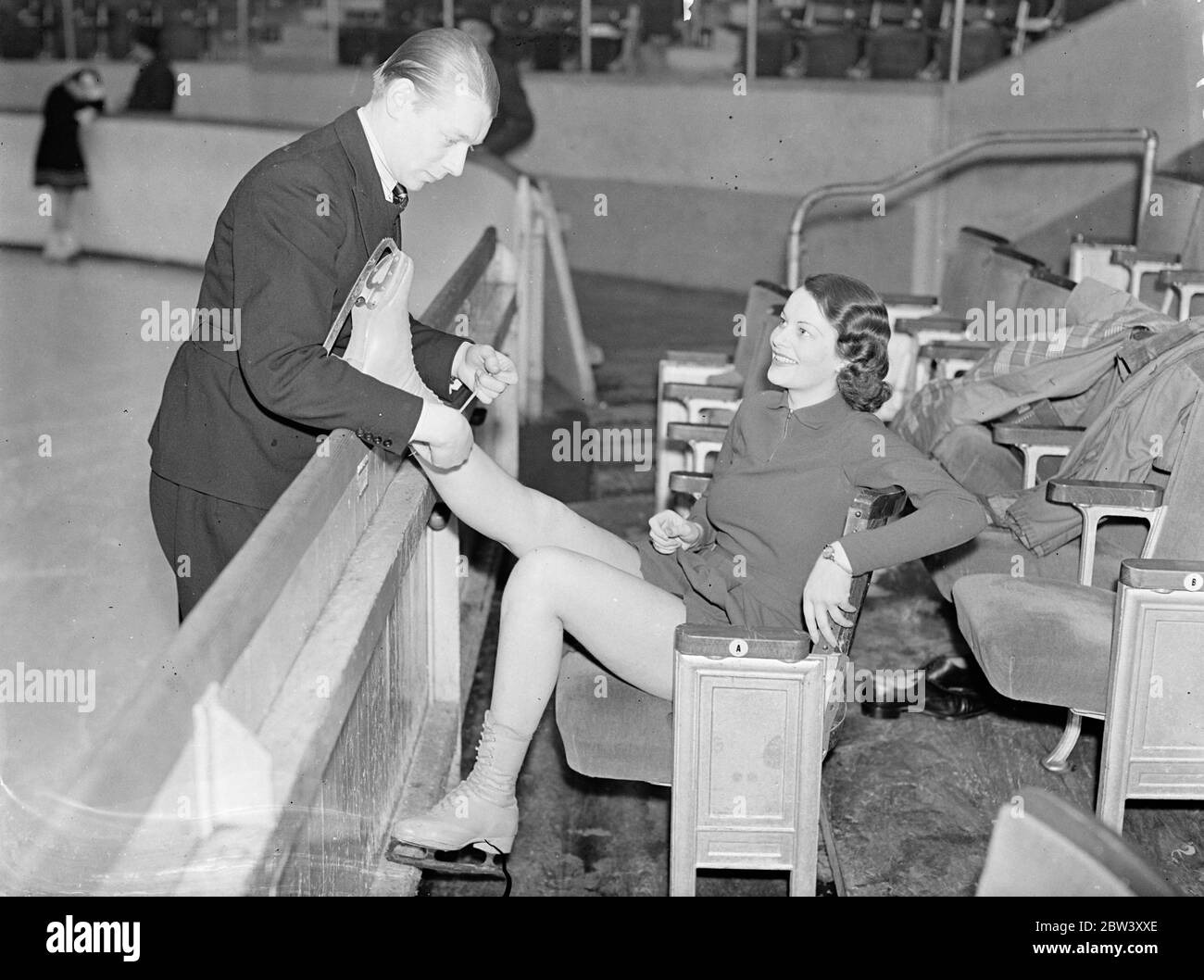 London Schauspielerin geht Skaten, um fit zu halten. Miss Dorothy Oldfield, die Filmschauspielerin, die jetzt in der Wiederbelebung von "The Squeaker" im Strand Theatre auftritt, hat das Skaten als Mittel der Erhaltung der Passform aufgenommen. Miss Oldfield wird von Larry Richards, dem Harringay Areana Profi, auf dem Eis tanzen beigebracht. Foto zeigt, Larry Richards Schnürung Miss Dorothy Oldfield ' s Skating-Stiefel in Harringay Arena. 13 März 1937 Stockfoto