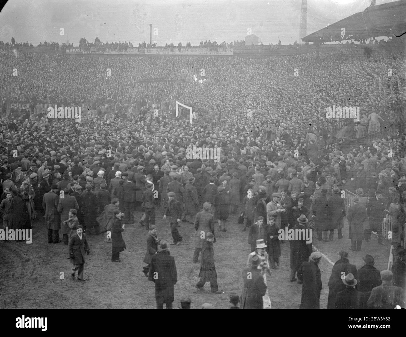 Millwall Spieler fliehen, wie Tausende Feld nach Cup Unentschieden Sieg eindringen. Millwall Spieler mussten vom Spielfeld fliehen, als Tausende ihrer überfreudeten Fans nach dem 2 - 0 Sieg des Teams über Manchester City in der sechsten Runde des F A Cup in "The Den", New Cross auf das Feld aufstiegen. Bald war das ganze Feld mit Tausenden von Menschen eingeklemmt. Foto zeigt, der Platz mit Menschen bedeckt, nachdem er Spiel. März 1937 Stockfoto