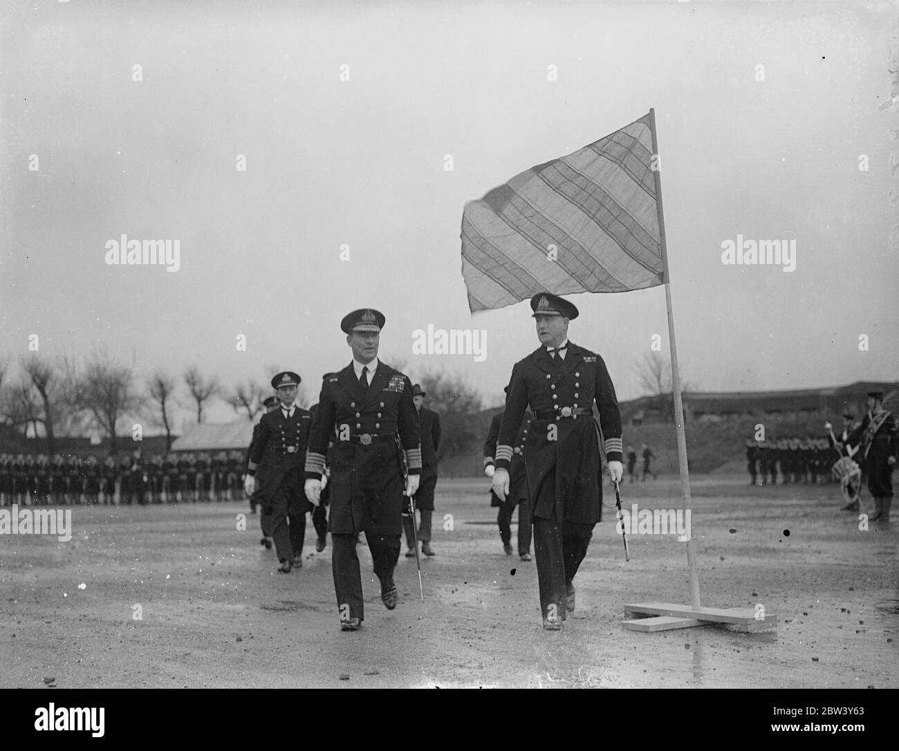 Admiral Evan inspiziert Navy Training School von Mann, der vom Jungen zum Kapitän ' s Rang stieg befohlen. Admiral Sir E. R. Evans (Evans of the Broke), Kommandant des Nordens, inspizierte die neuen Jungen Ausbildungsstätte. HMS Wildfire , die unter dem Kommando von Kapitän J Figgins . Kapitän Figgins ist der erste Kommandant der Schule, die in dem Gebäude, wo er seine Marine Ausbildung als Junge erhalten etabliert ist. Er trat der Marine im Jahr 1902 und wurde von der unteren Deck zu Commision Rang befördert. Foto zeigt, Admiral Sir E R Evans und Captain J Figgins unter der Flagge auf Stockfoto