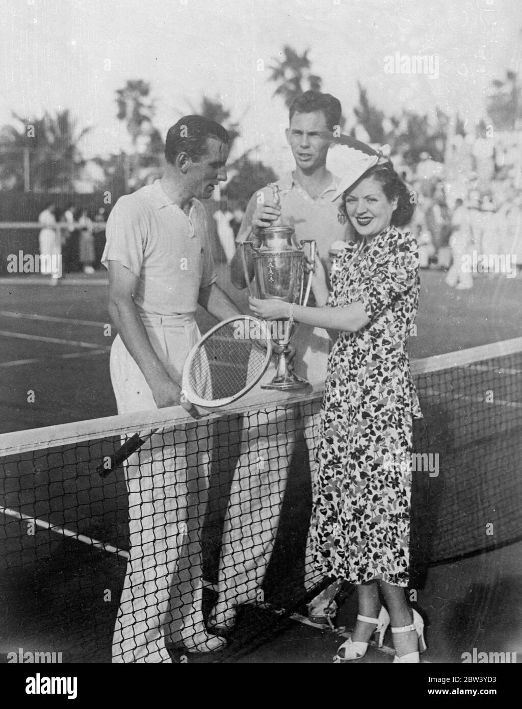 Ellsworth Vines sagt, dass er Fred Perry geschlagen hat. Ellsworth Vines, der amerikanische Tennisprofi, erhielt die Miami Beach Trophäe von Miss Terry Lawlor, Schauspielerin, nachdem er Fred Perry, den britischen Meister 5 - 7, 7 --5, 6 --4, in ihrem Spiel in Miami, Florida geschlagen hatte. Foto zeigt, Terry Lawlor Übergabe der Miami Beach Trophäe an Ellsworth Vines in Miami mit Fred Perry auf der linken Seite. 12 Februar 1937 Stockfoto