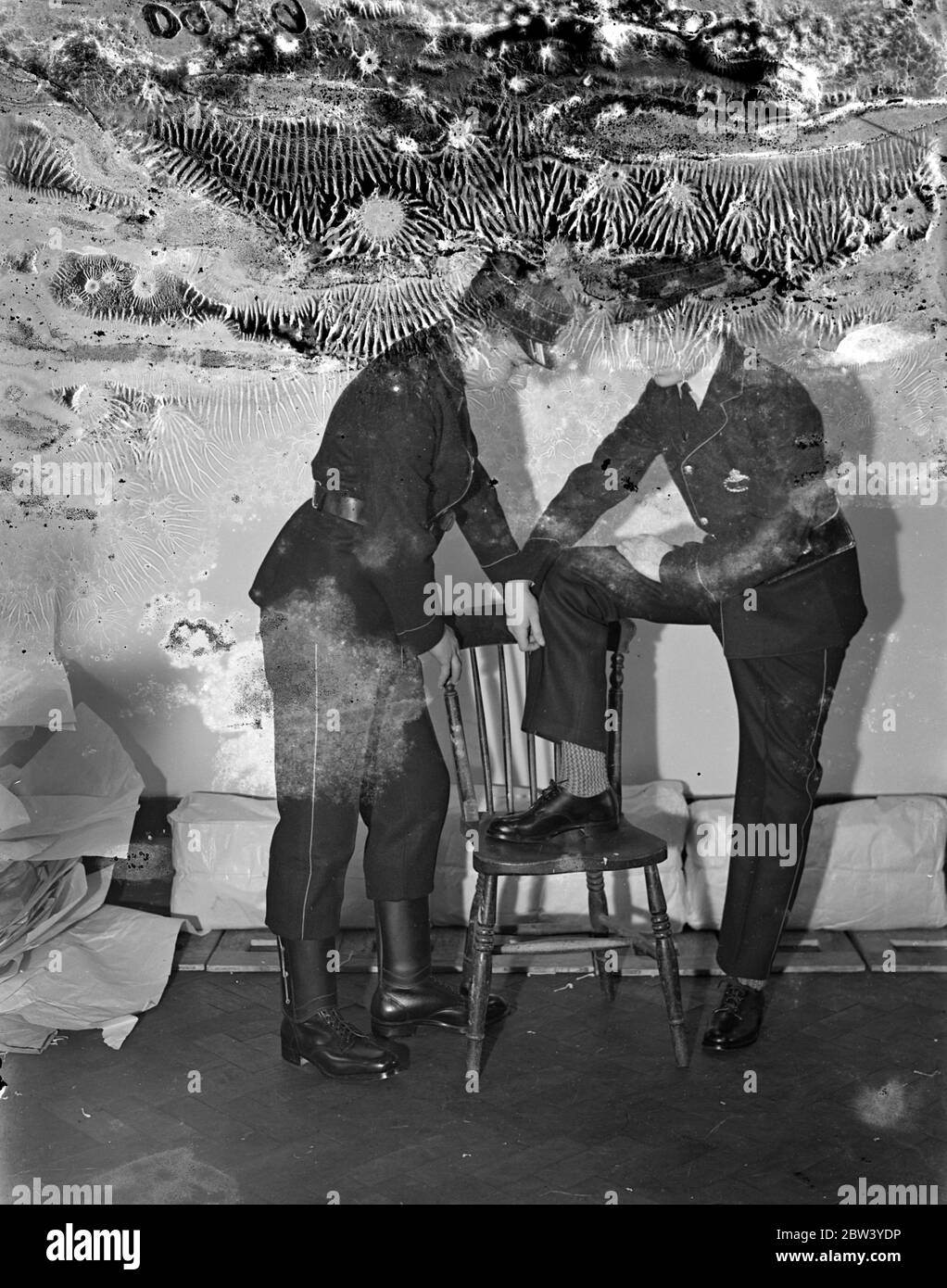 Neue Uniformen werden Post Office Messenger Jungen intelligenter für Krönung machen. Schuh Stiefel ersetzen. Eine komplette Überarbeitung der Kleidung wird von der Post durchgeführt, um die Bote-Jungen für das Krönungsjahr noch klüger zu machen. Eine neue Sommeruniform aus leichterem Material wird geliefert, komplett mit neuer Leggings und Tasche. Schuhe sollen Boote ersetzen. Aber obwohl sie jetzt einen Kragen und Krawatte tragen, ist ein Hemd mit offenem Hals verboten. Foto zeigt: Junge in der neuen Uniform zeigt seine neuen Schuhe an Bote in der alten Art Kleid. 24 Februar 1937 Stockfoto