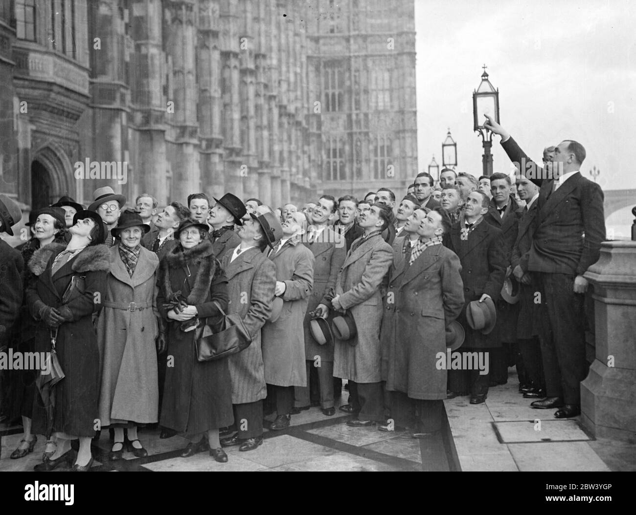 Major Gwilym Lloyd George hilft aus einem anderen walisischen MP. Zeigt Wähler um Parlamentsgebäude . Major Garonwy Owen , MP , für Carnarvonshire , die Hilfe von Major Gwilym Lloyd George , MP , für Pembrokeshire , wenn eine Partei von Major Owen ' s Wähler besuchten die Houses of Parliament . Der Männerchor Penrhyn wurde von Major Owen selbst und anderen Besuchern aus Major Owens Wahlkreis gezeigt hatte Major Lloyd George als Führer. Major Lloyd George ist Sohn von David Lloyd George . Foto zeigt, Major Gwilym Lloyd George weist auf Major Owens Wähler Verbesserungen Stockfoto