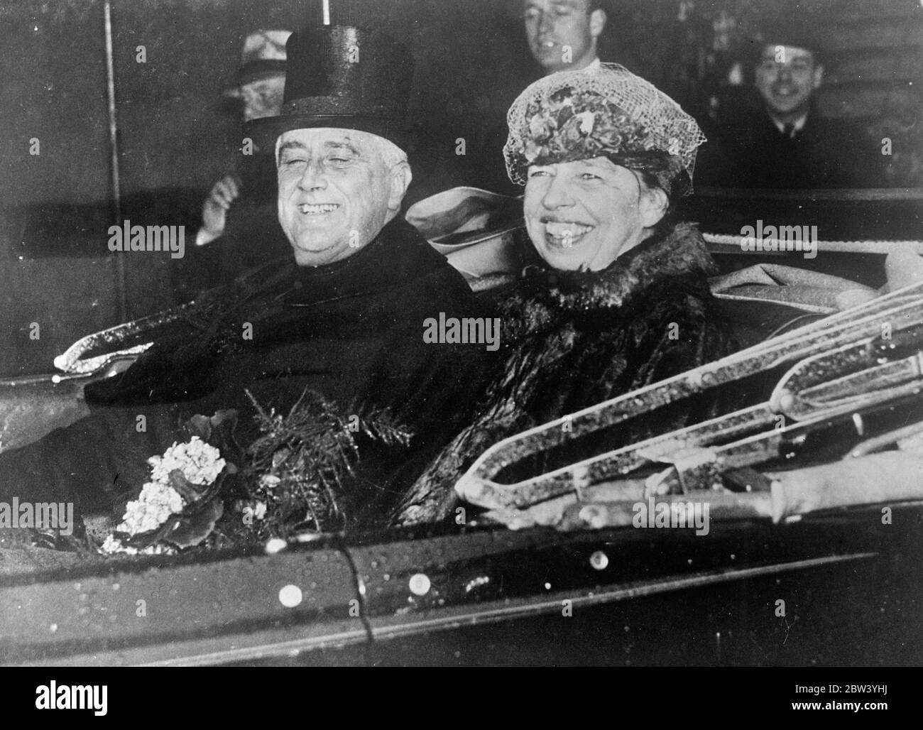 Roosevelts Lächeln bricht durch den Regen bei der Einweihung . Obwohl von dem starken Regen, der während der Zeremonie niedergegossen, getränkt, gelingt es Pres Franklin D Roosevelt, sein berühmtes Lächeln zu geben, als er den Eid bei seiner Einweihung für seine zweite Amtszeit als Präsident der Vereinigten Staaten nahm. Riesige Menschenmengen standen stundenlang Hauptstadt , Washington , DC , um die Eröffnungsrede zu hören . Foto zeigt, regen getränkten Präsident Roosevelt und Frau Roosevelt Lächeln breit, wie sie zurück zum Weißen Haus in den Regenguss nach der Einweihung fahren. 27. Januar 1937 Stockfoto
