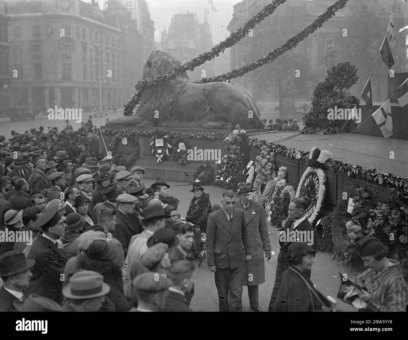 Trafalgar Day gedenkt an Nelson's Column. Große Menschenmengen beobachteten, wie Vertreter der Herrschaften und Kolonien Kränze auf der Nelson-Säule am Trafalgar Square zum Trafalgar Day niederlegten. Foto zeigt: Die Szene in Trafalgar Square Kränze wurden auf der Nelson-Säule gelegt. 21. Oktober 1936 Stockfoto