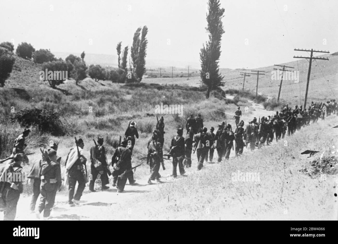 Loyalisten marschieren zur Talavera Front hinauf. Foto zeigt: Regierungsmilizen schreiten auf einer Straße an der Talavera Front südlich von Madrid vor, wo die Loyalisten versuchen, den Vormarsch der Rebellen zurückzuhalten, die versuchen, zur Erleichterung von Toledos Alcazar durchzubrechen. Laut Berichten der Rebellen sind die Aufständischen nur wenige Kilometer von ihrem Ziel entfernt. 17. September 1936 Stockfoto