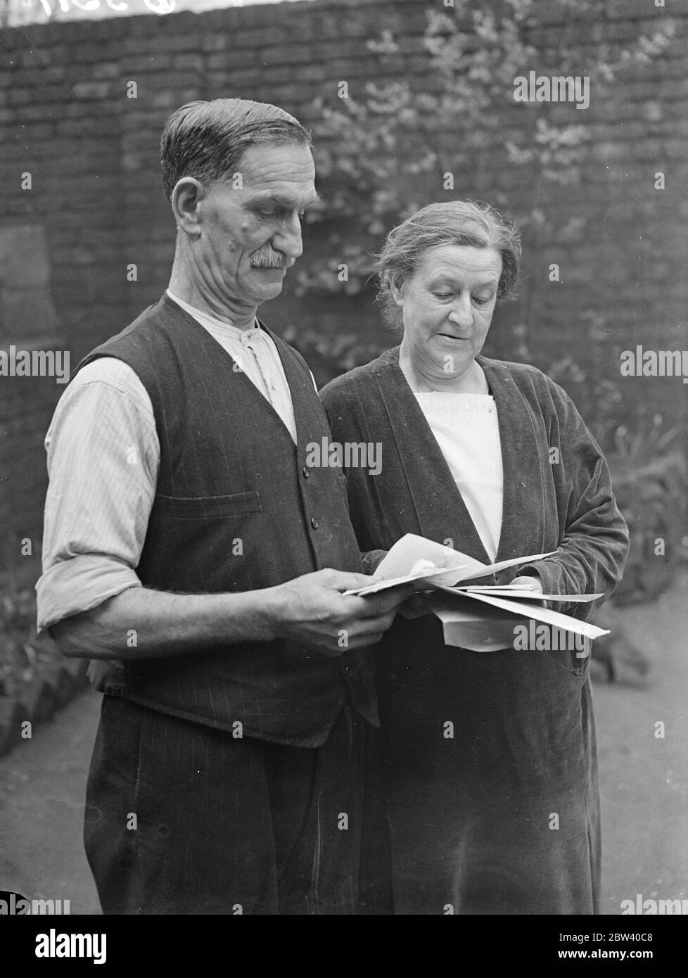 Jetzt arbeitete sie mit Dr. Crippen feiert goldene Hochzeit . Miss Annie Watson von Georgiana Street, Camden Town, eine ehemalige Krankenschwester, die mit Dr. Hawley Crippen, der Giftmischer arbeitete, und war ein Freund von Miss Ethel le Neve, feiert ihre goldene Hochzeit. Sie beschreibt Crippen als milden, gut manierierten Mann und extrem höflich. Crippen war der erste Mann, der mittels Radio verhaftet wurde. Er wurde an Bord eines transatlantischen Linienschiffes nach einer von England übermittelten Nachricht verhaftet. Foto zeigt, Miss Annie Watson und ihr Mann fotografierten Lesen Telegramme von Glückwünschen auf ihren go Stockfoto