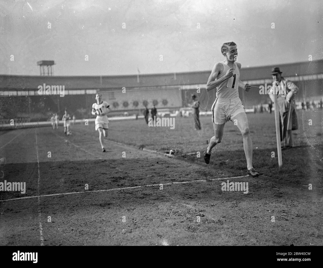 Finale der öffentlichen Schulen Leichtathletik in White City. Beenden Sie das 1 Meile Finale gewonnen von D. G. Percival of Kings, Wimbledon. R. C. Mace, von Elizabeth College Guernsey. 10. April 1937 Stockfoto