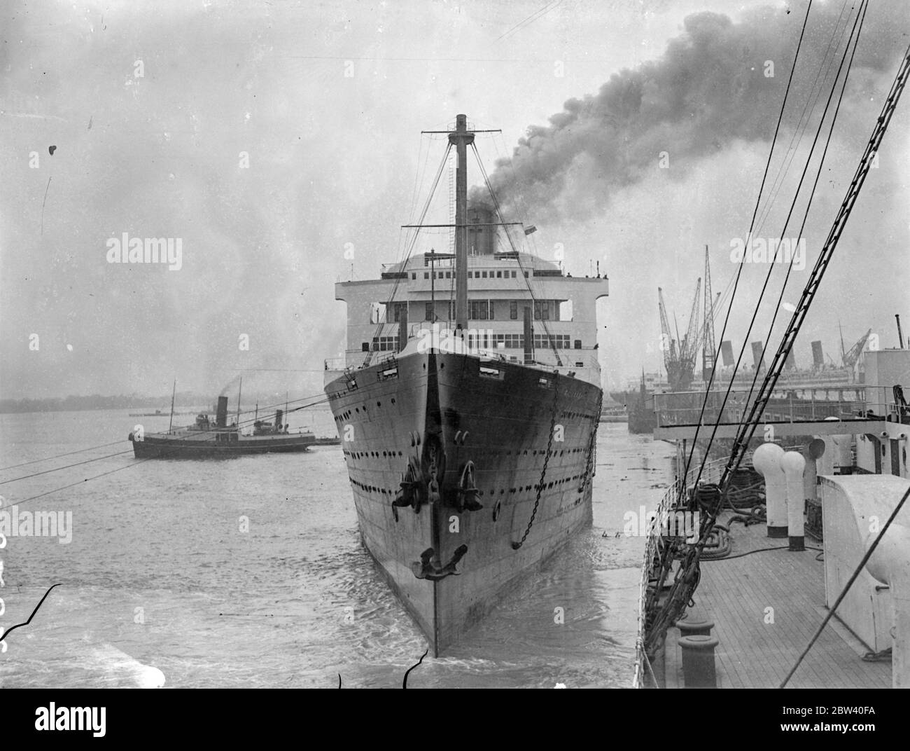 HMS Caledonia, früher der Cunard White Star Liner Majestic, segelte von Southhampton Rosyth aus, um eine neue Karriere als Ausbildungsschiff zu beginnen. Die Arbeit, sie zu bekehren, hat viele Monate gedauert. Foto zeigt: Arbeiter, die bei der Umwandlung halfen, HMS Caledonia zu beobachten, wie sie von Southhampton aus segelt. 08. April 1937 Stockfoto