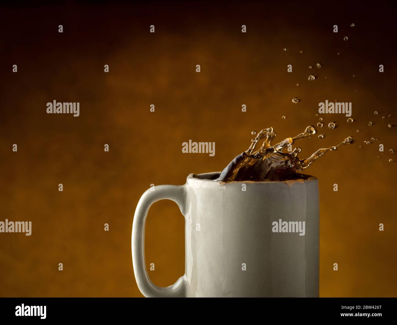 Kaffee spritzt aus Kaffeebecher Stockfoto