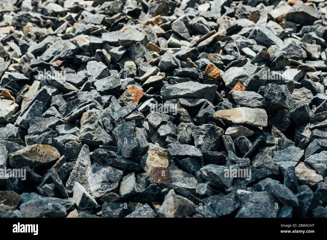 Grobe Steine, Schotter, Granitkies Nahaufnahme. Die raue Textur des Steins. Hintergrund des Baumaterials. Struktur Stockfoto