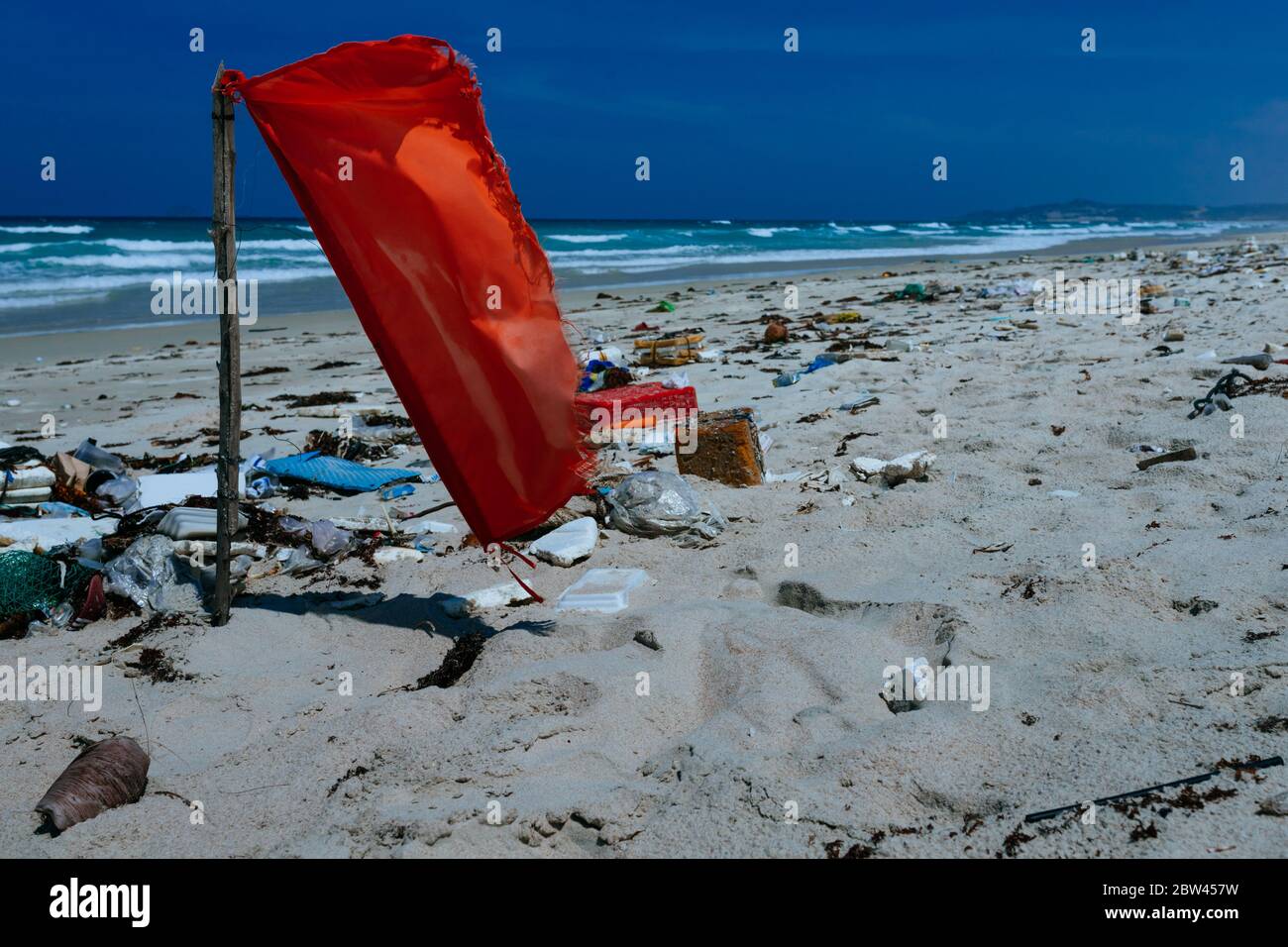 Plastikflaschen und anderer Müll, der auf die Sandküste geworfen wird, Müll am Meeresstrand, ökologisches Problem. Umweltverschmutzung. Schmutziger Sandstrände Stockfoto