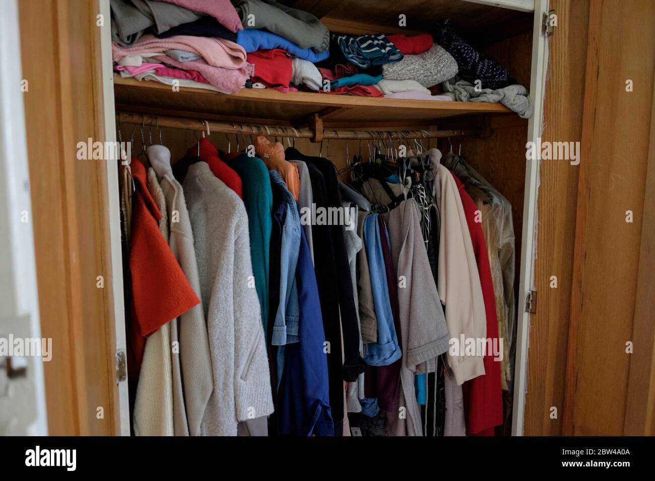Kleidung hängt in der Garderobe einer kürzlich verstorbenen älteren Frau, Großbritannien. Stockfoto