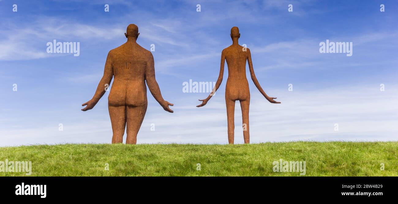 Panorama einer Statue eines Mannes und einer Frau auf einem Deich in Friesland, Niederlande Stockfoto