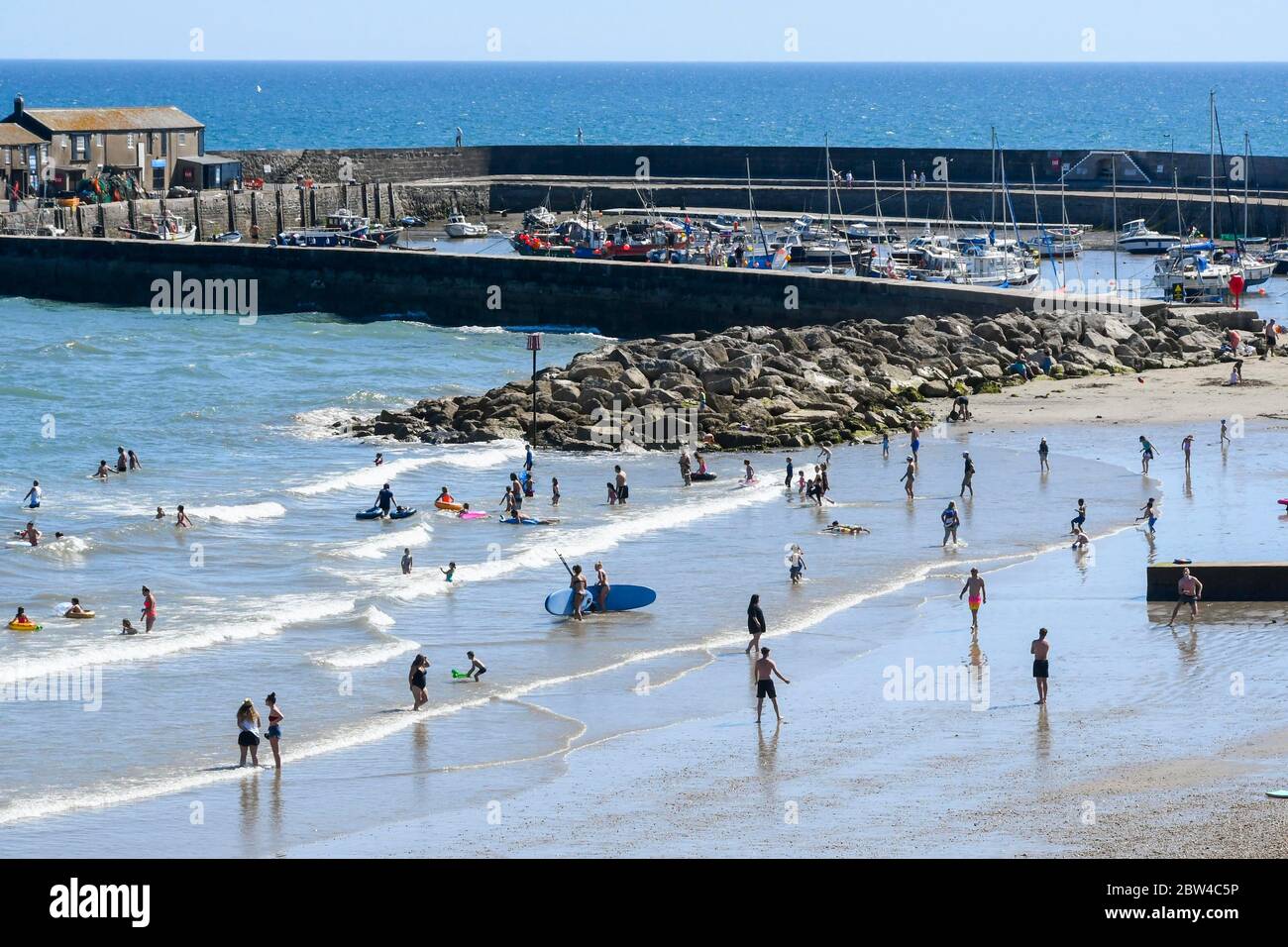Lyme Regis, Dorset, Großbritannien. Mai 2020. Wetter in Großbritannien. Der Strand im Badeort Lyme Regis in Dorset ist voll mit Familien und Sonnenanbetern, die im Meer paddeln, um sich in der heißen Sonne am Nachmittag abzukühlen. Bild: Graham Hunt/Alamy Live News Stockfoto