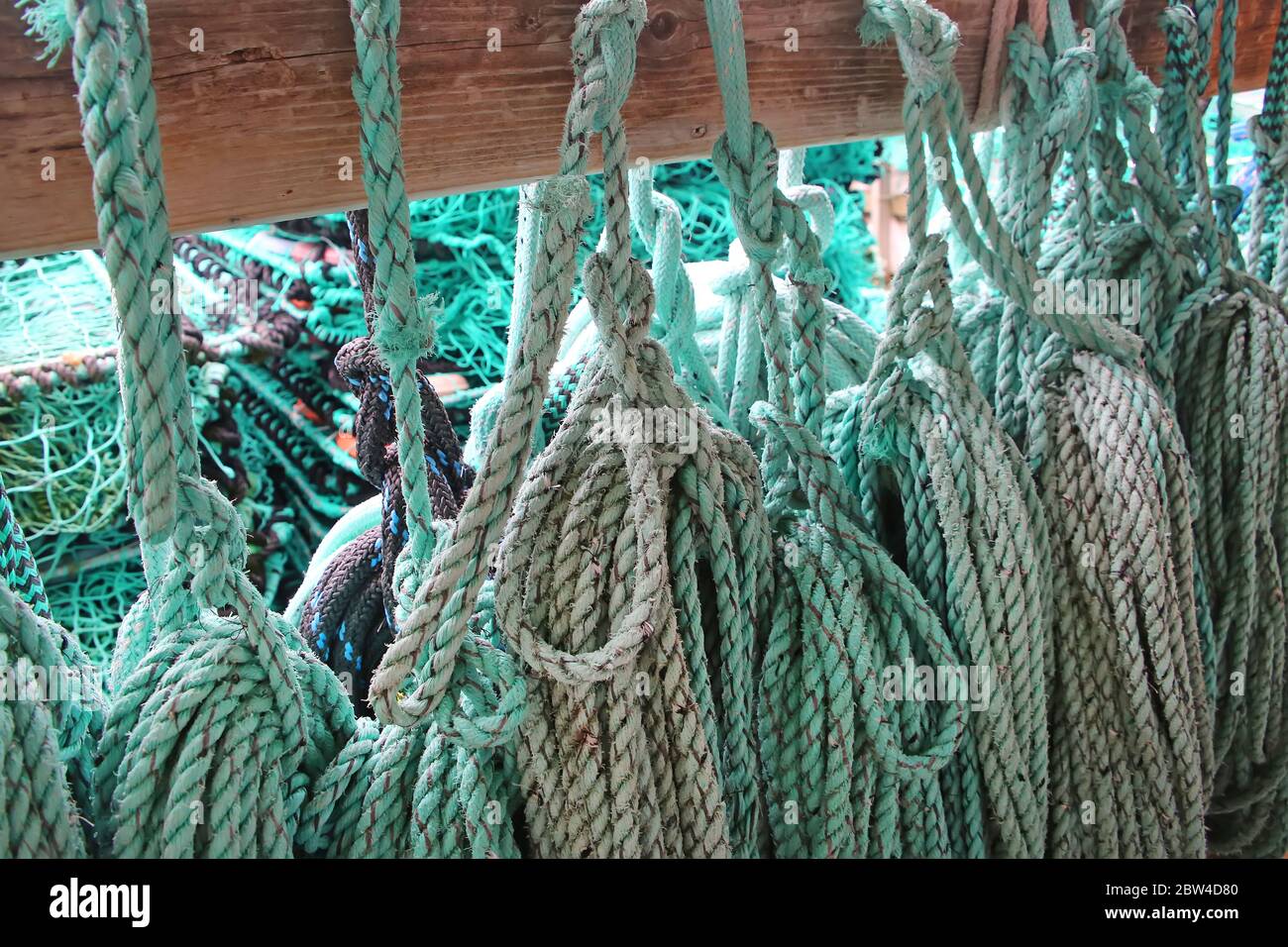 Nahaufnahme von grünem blauem Türkis-Seil Aufhängen auf Holz zum Angeln oder Segeln, Norwegen. Stockfoto