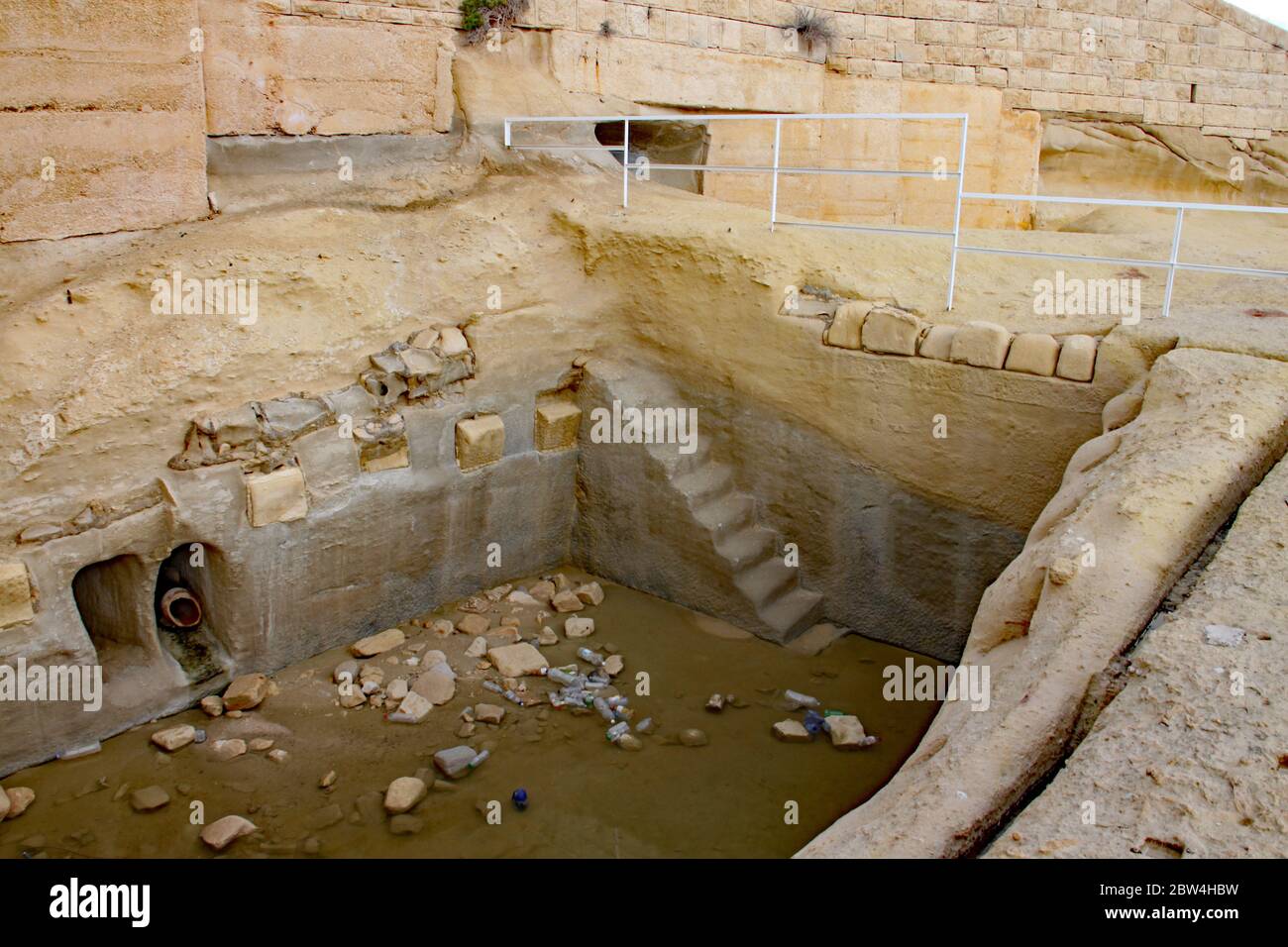Alte abgenutzte Treppen führen hinunter zu einem zerstörten Keller in Sliema auf Malta Stockfoto