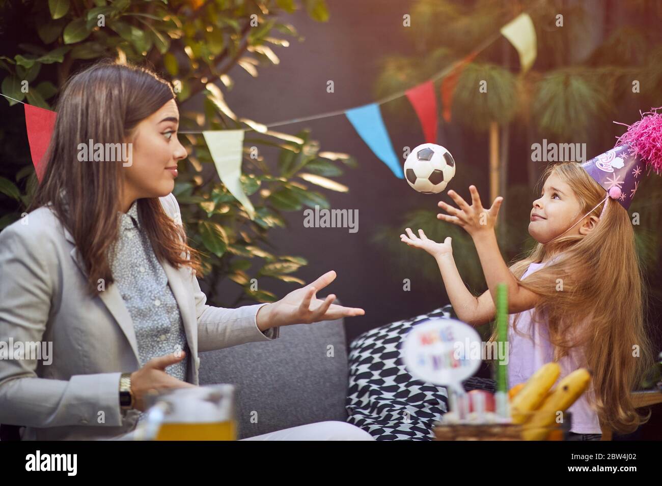 Kinder Geburtstagsfeier . Kleine süße Mädchen in Geburtstagsmütze halten Stapel von Geburtstagsgeschenke. Stockfoto