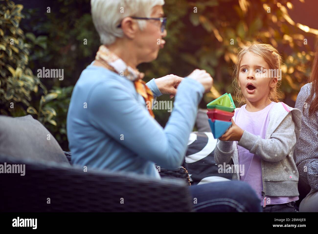 Glückliche Großeltern genießen mit Enkelkind und spielen mit Papier Boot. Stockfoto