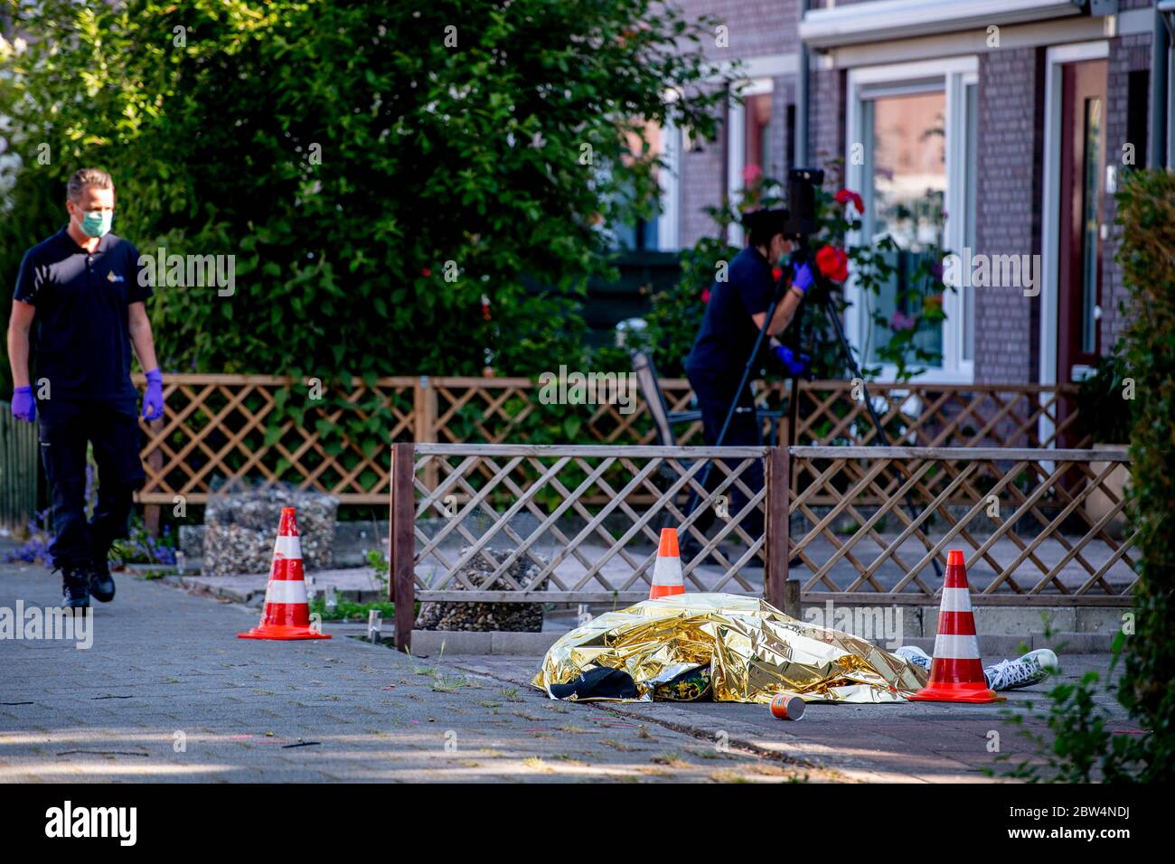 Der Leichnam des Verstorbenen liegt am Tatort.EIN Mann (30) wurde erschossen, nachdem er ein Haus in Rotterdam-Zuid ijsselmonde bombardiert hatte. Ein Polizeisprecher sagt, dass es offenbar eine Liquidation auf den Straßen gibt. Zwei Verdächtige wurden festgenommen. Stockfoto