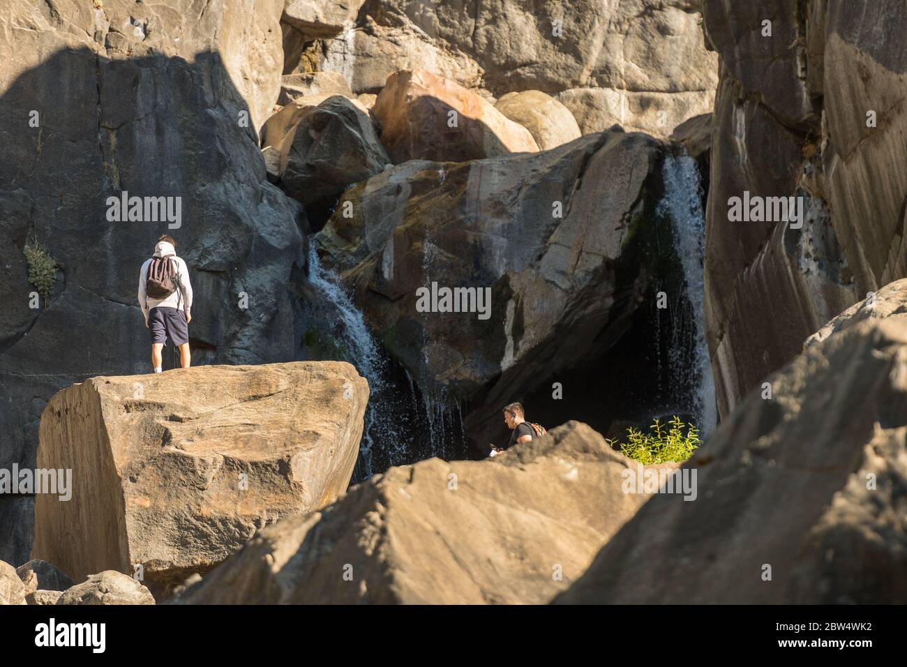 Touristen genießen das Wasser am Fuße des Bridalveil Falls im Yosemite National Park Stockfoto