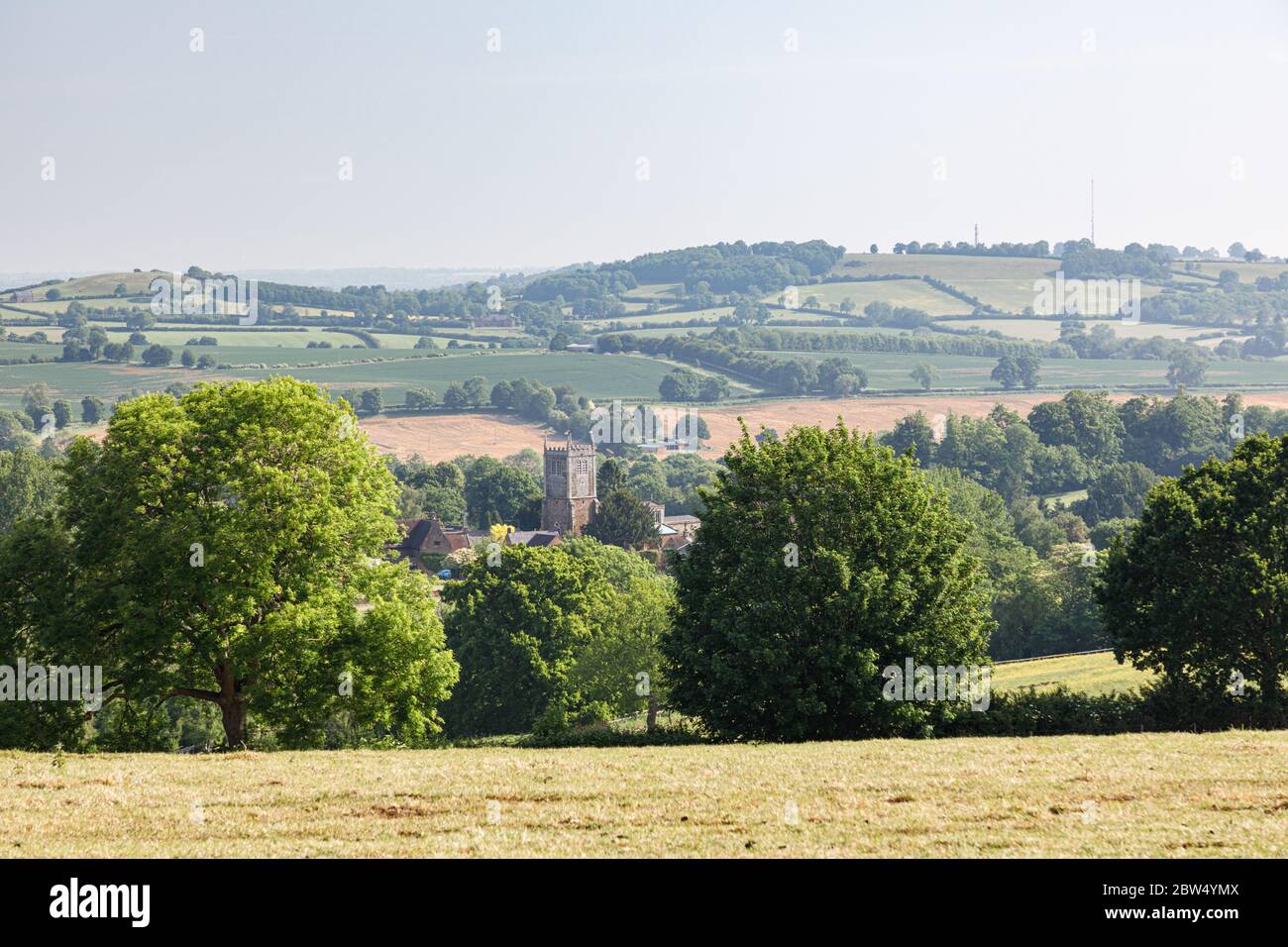 Badby, Northamptonshire, UK - 28. Mai 2020: Der Kirchturm im Dorf Badby ist von Bäumen umgeben, hinter denen sich die Landschaft sanft abrollt. Stockfoto