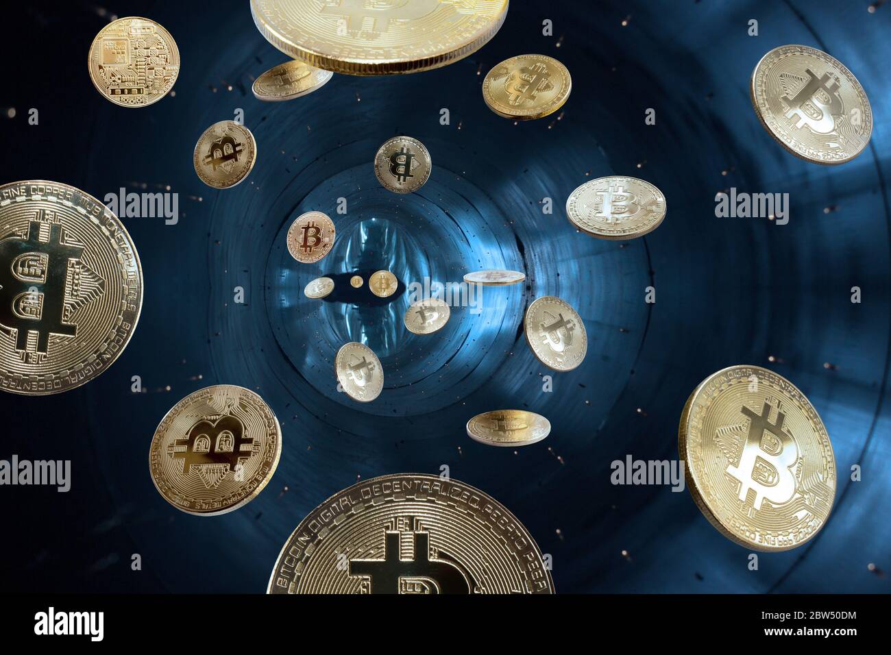 Auf blauem Hintergrund sind Goldmünzen virtuelle digitale Kryptowährung - Bitcoin fallen in das schwarze Loch im Raum Stockfoto