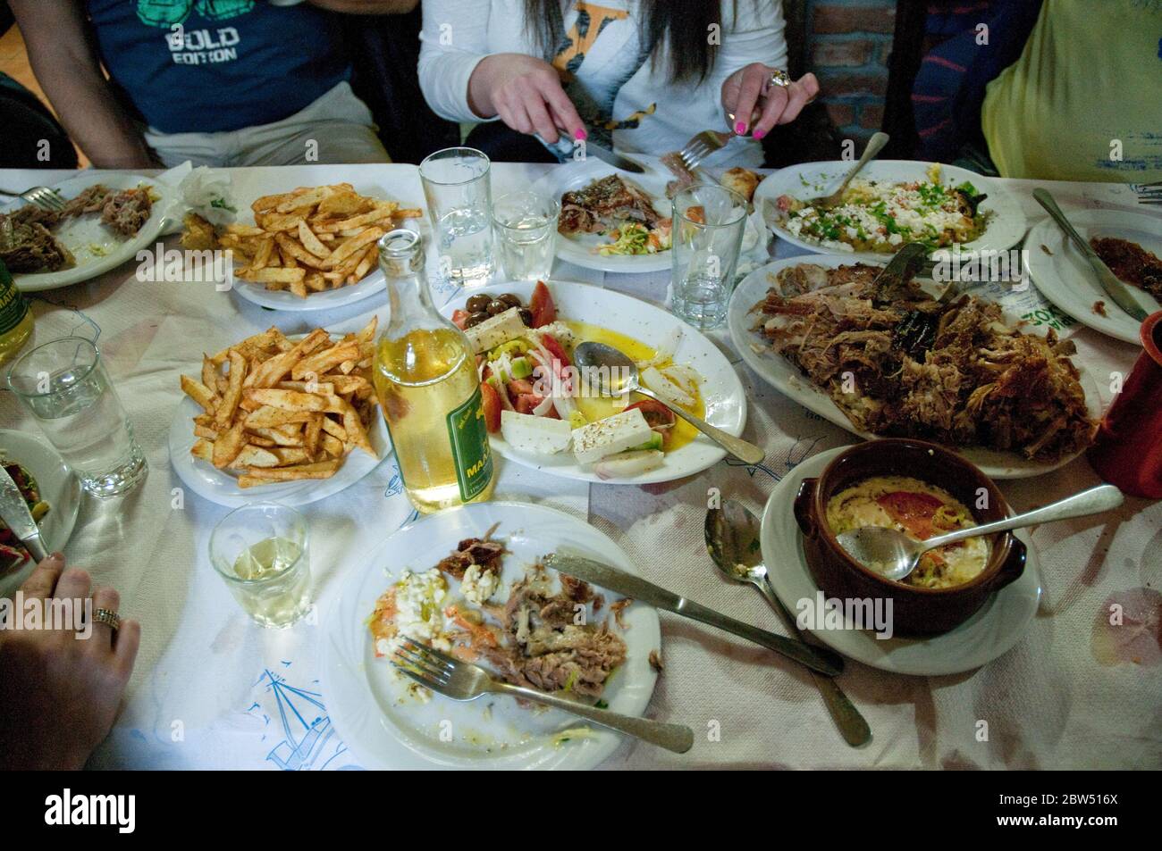 Eine Gruppe griechischer Freunde, die in einem lokalen Dorfrestaurant in der Stadt Profitis Ilias auf der Insel Samothraki, Thrakien, Griechenland zu Abend essen. Stockfoto