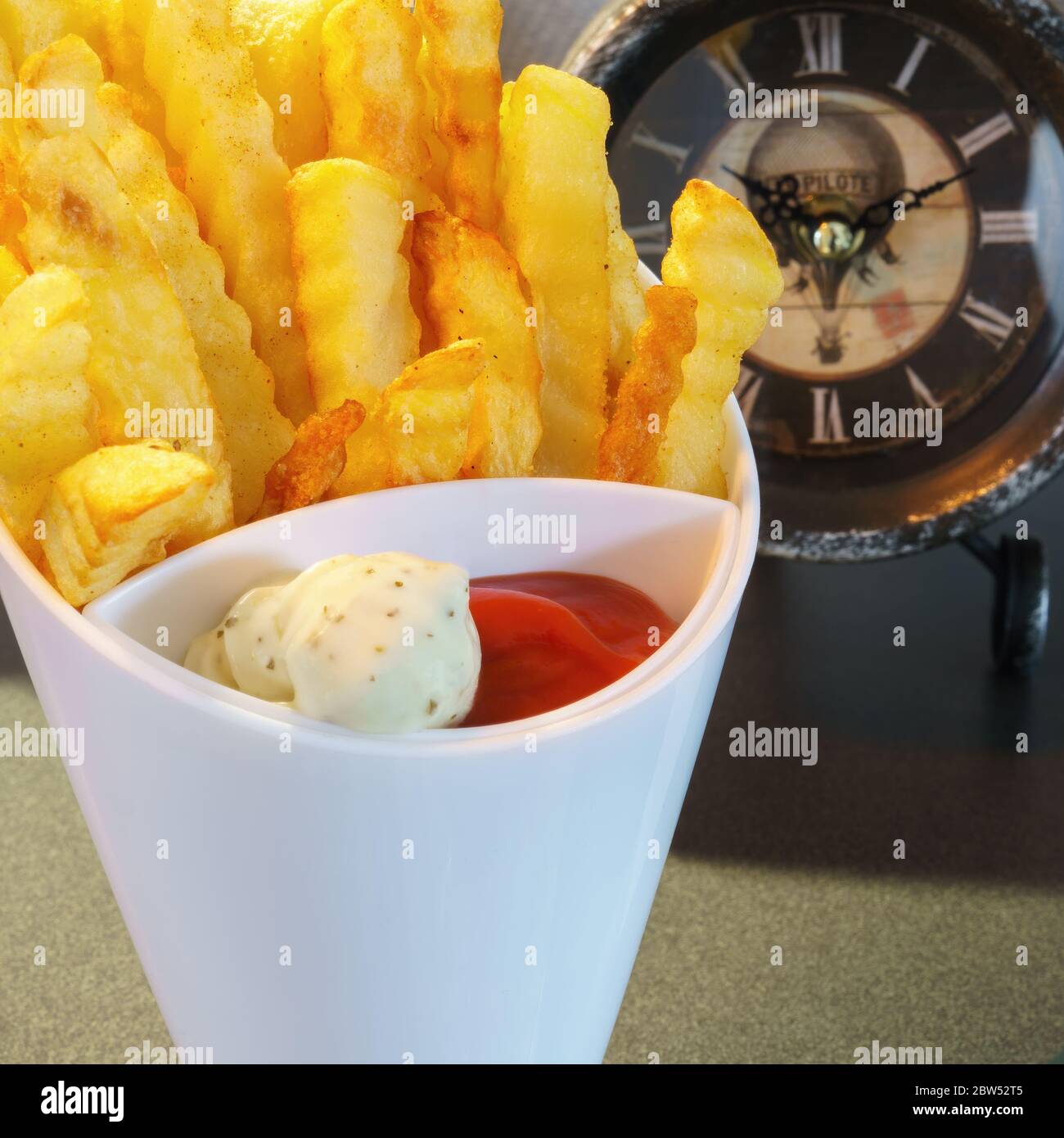 Ein weißes High Top mit pommes Frites, Ketchup und Mayonnaise, ganz nah Stockfoto