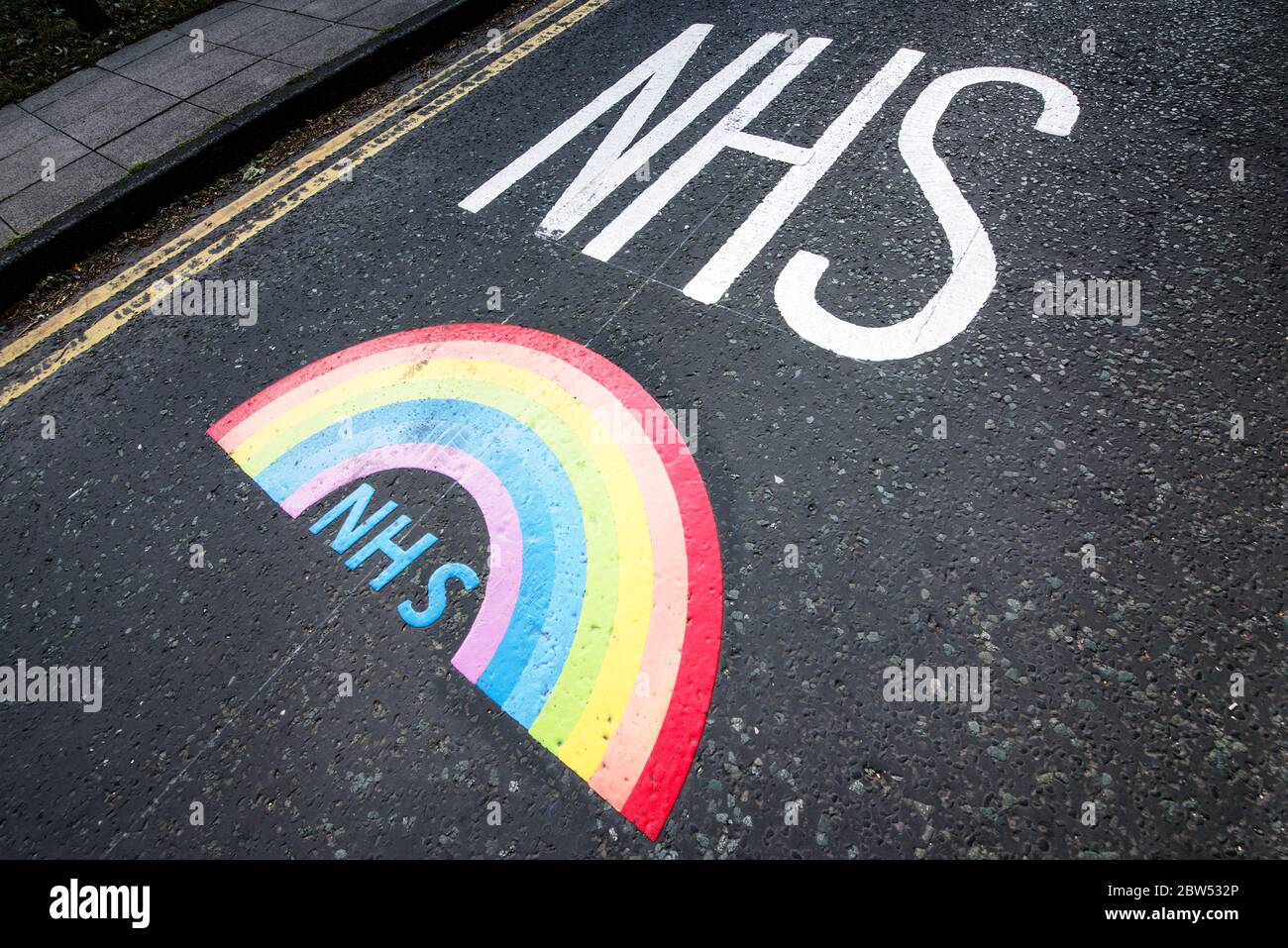 Neu bemalte Straßenmarkierungen Vielen Dank NHS und ein Regenbogen wurden vor einem medizinischen Zentrum in Manchester gemalt, um allen Mitarbeitern des NHS zu danken. Stockfoto