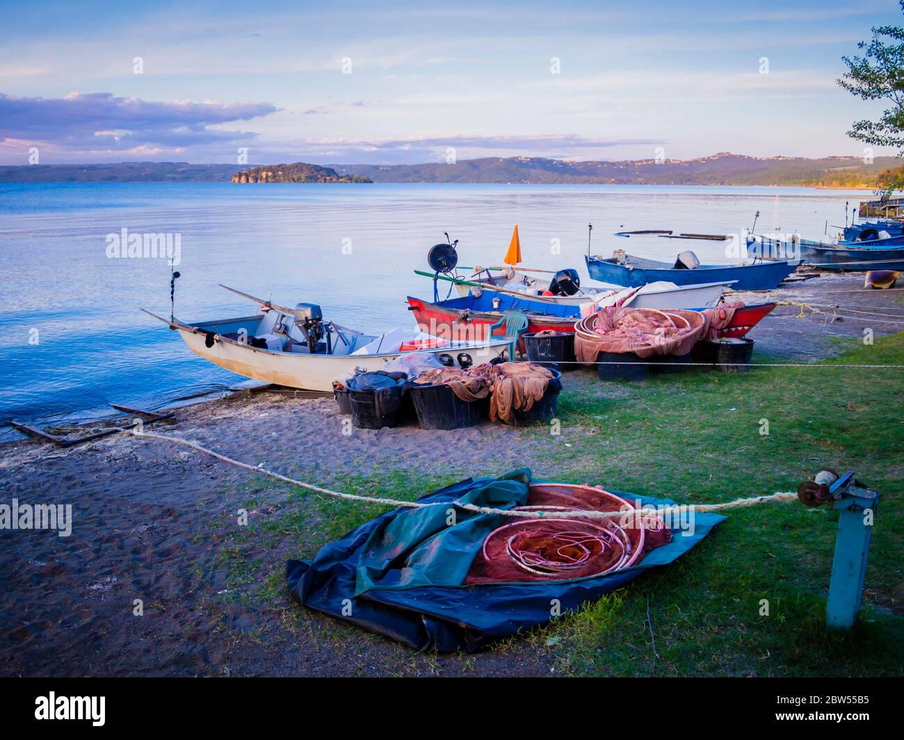 Eine Reihe von typischen Fischerbooten legte am Marta-Strand an, einem kleinen mittelalterlichen Dorf am Bolsena-Seeufer, Provinz Viterbo, Latium, Italien Stockfoto