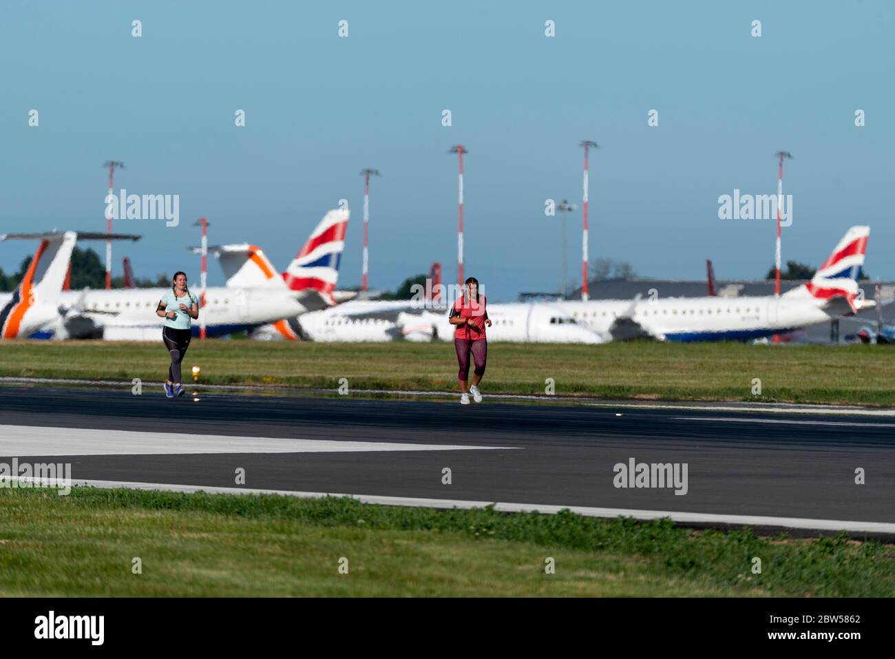 Gesponserter Spendenlauf, der auf der Start- und Landebahn am Flughafen London Southend, Essex, Großbritannien, stattfindet, da keine Flüge verfügbar sind. Geerdeter British Airways Jet Stockfoto