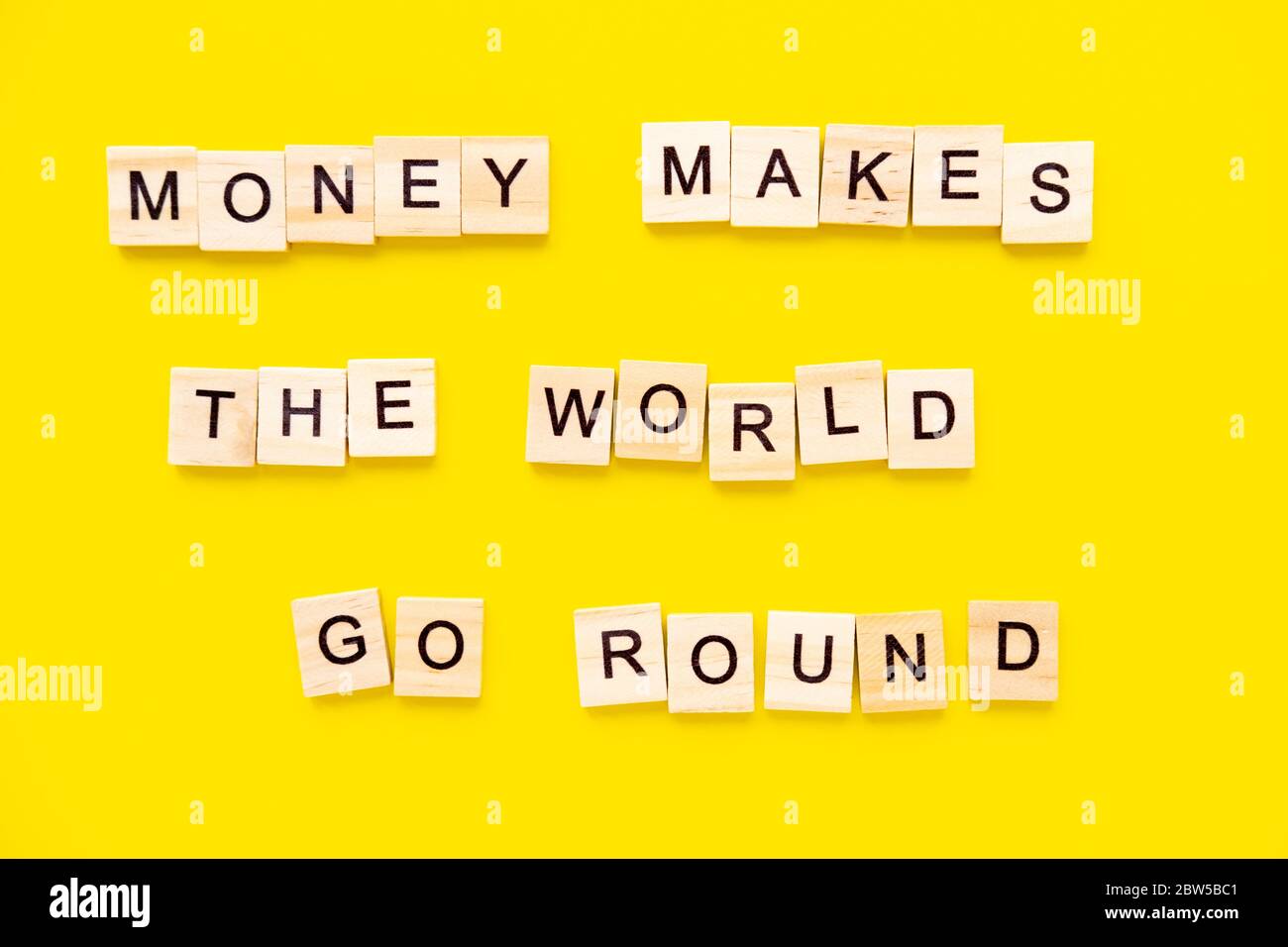 Sprichwörter Geld lässt die Welt auf gelbem Hintergrund umhergehen. Stockfoto